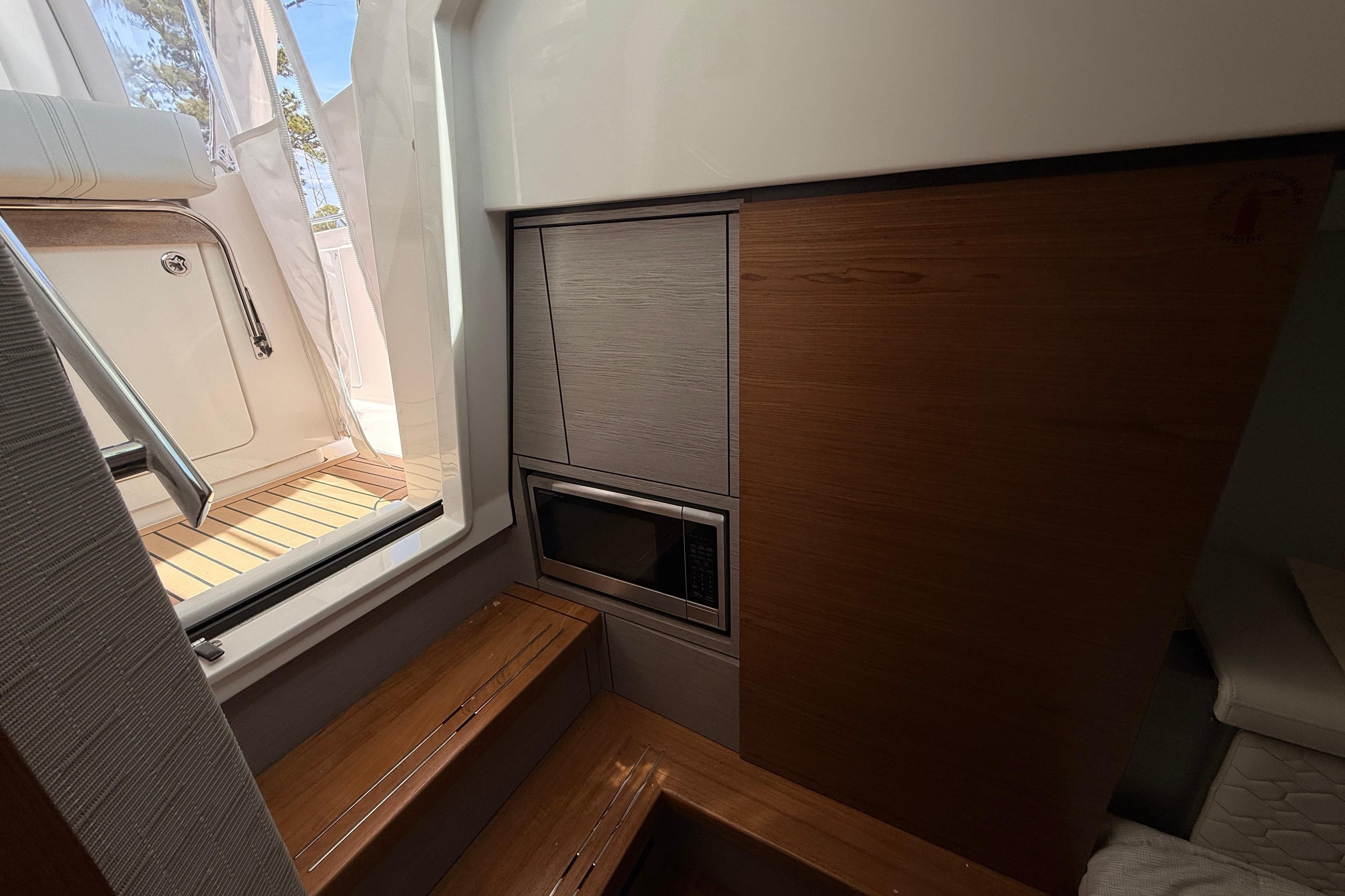 Interior of 2022 Tiara Yachts 38 LS, featuring wooden steps and built-in microwave.
