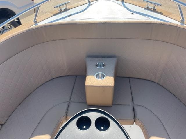 2023 Maxima 620 Retro boat interior with beige seating and cup holders.