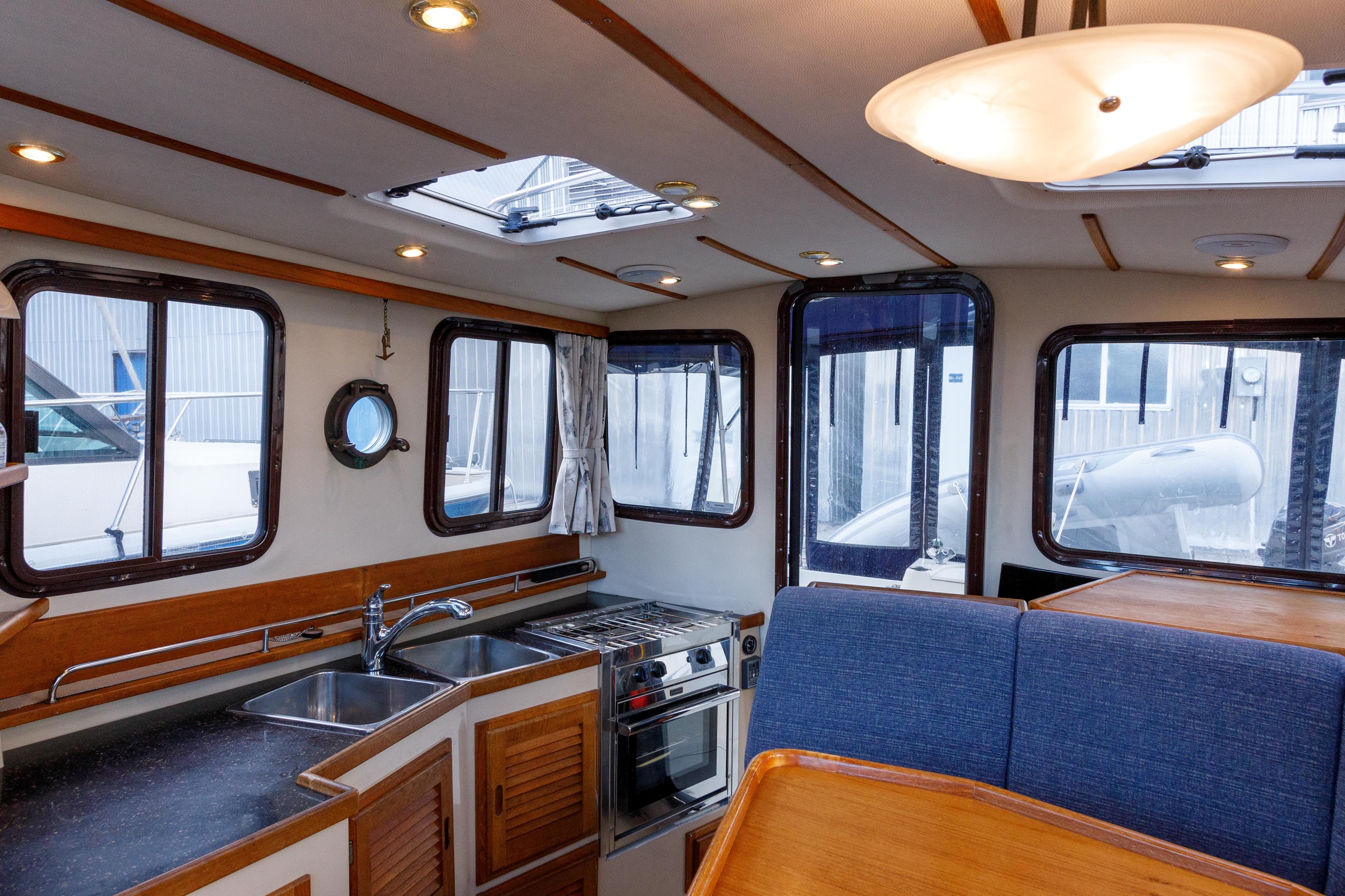 Interior of 2010 Ranger Tugs R-29 Sedan Luxury Edition with kitchen and seating area.