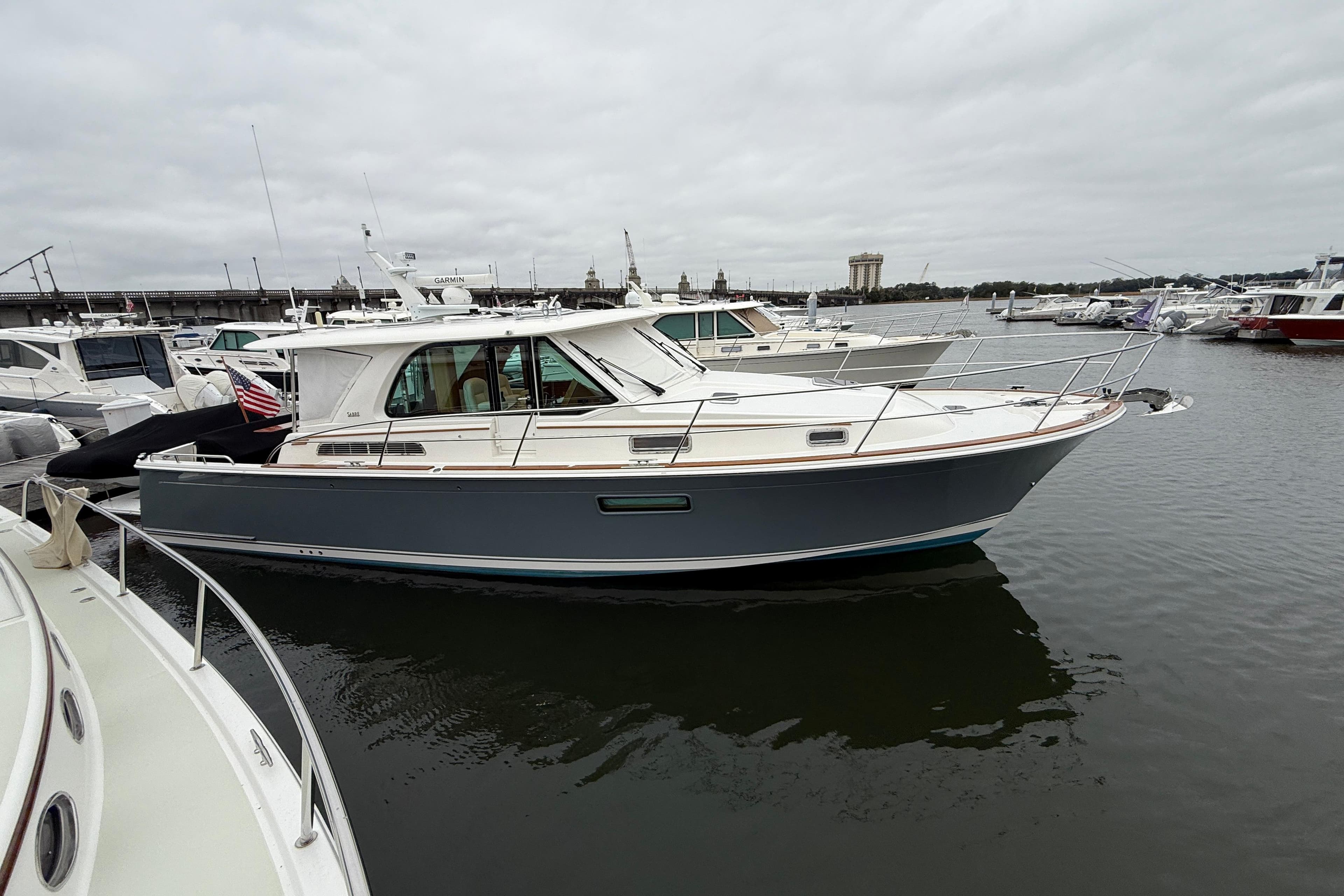 2023 Sabre 43 Salon Express yacht docked in a marina, overcast sky.
