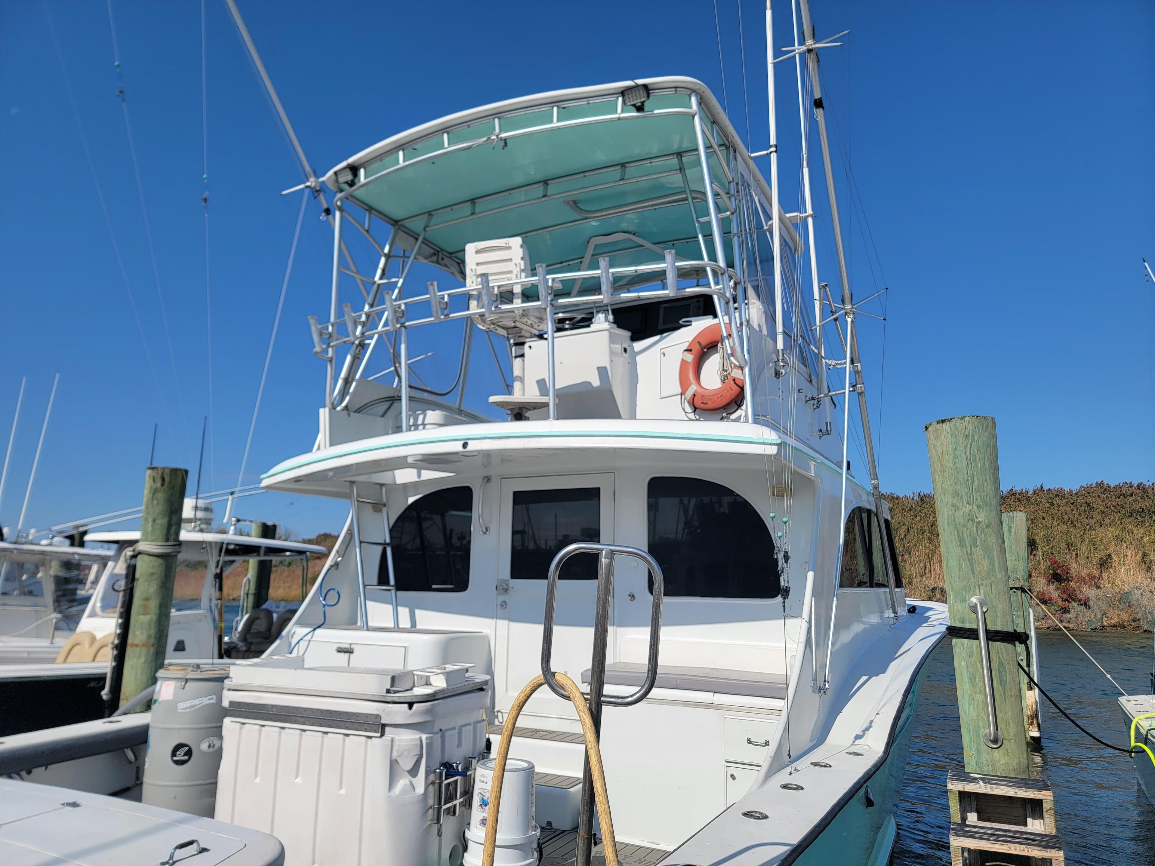 1998 Custom Carolina 45 Willis Boatworks docked, featuring a spacious upper deck and fishing equipment.