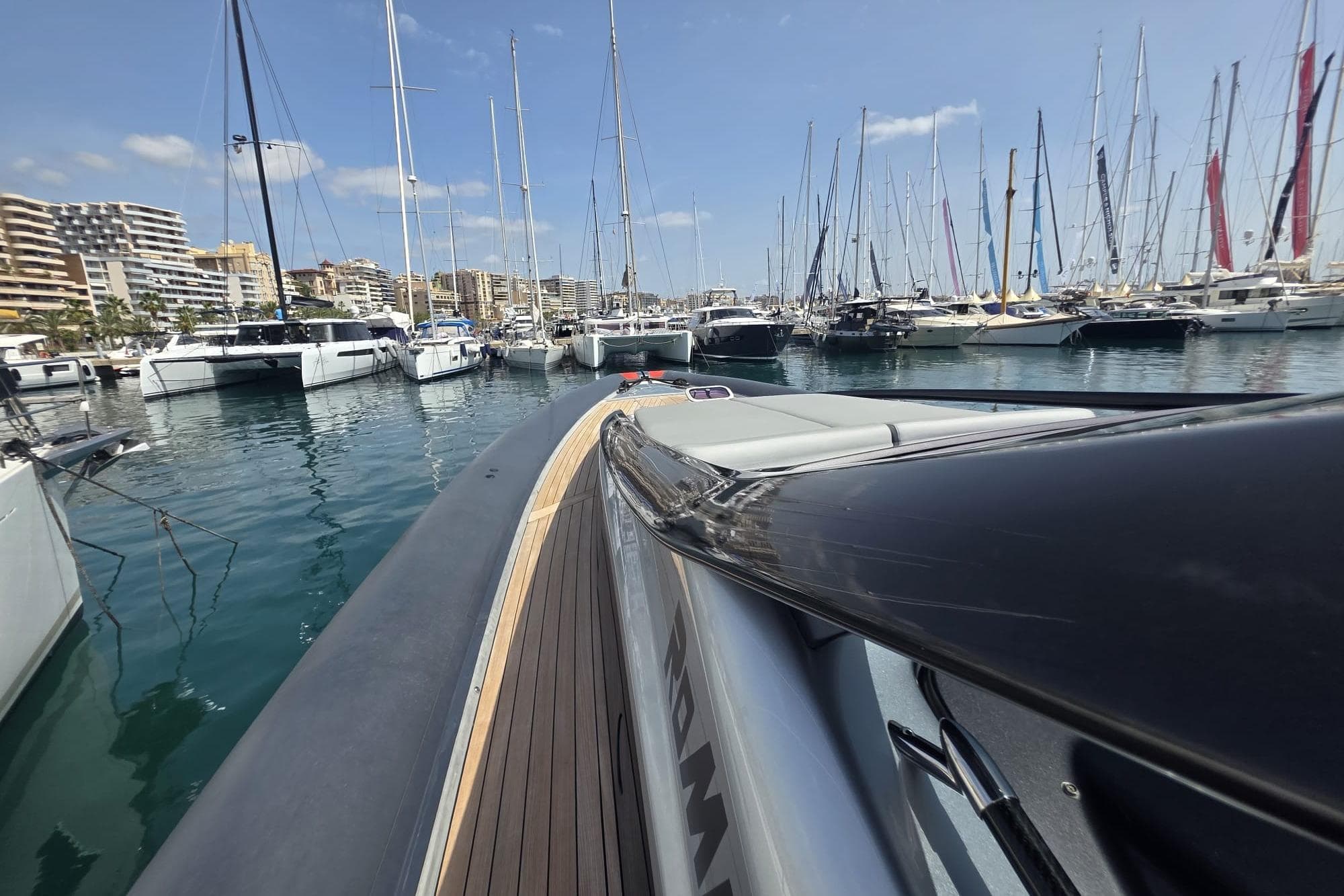 2019 Anvera 50 S yacht docked in a marina with sailboats and cityscape.