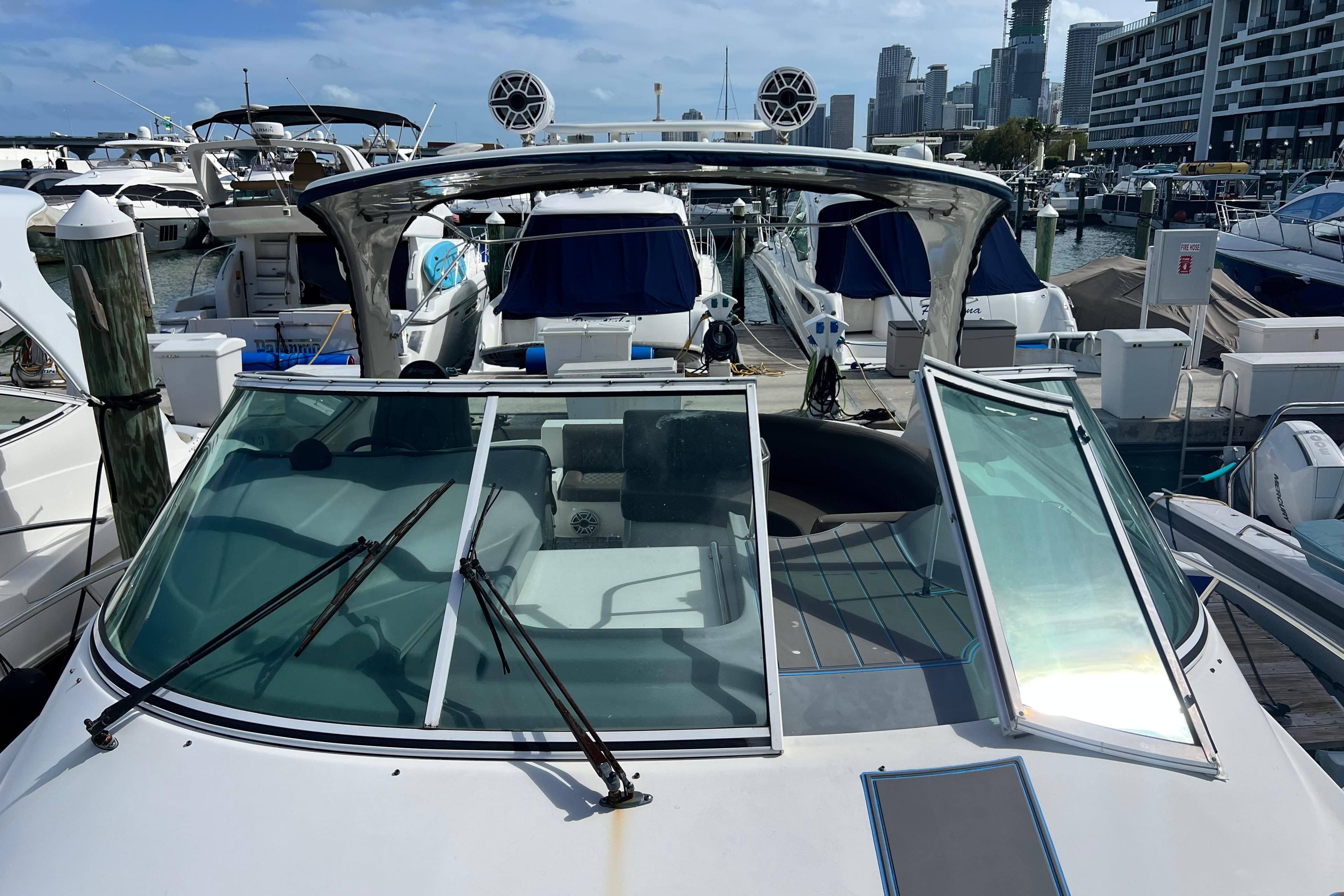 2005 Cruisers Yachts 440 Express docked at marina with city skyline backdrop.