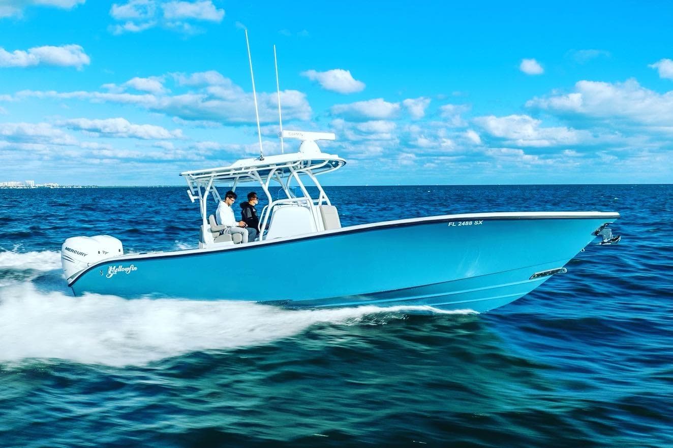 2025 Yellowfin 32 boat cruising on open water under a clear blue sky.