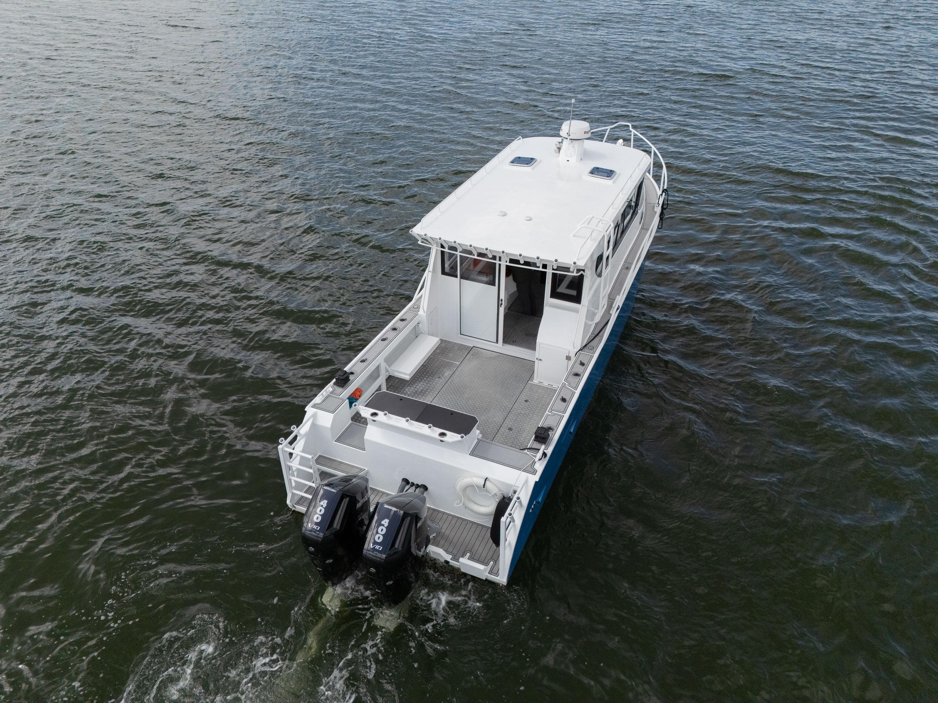Custom Ocean Craft 1106 boat, 2025 model, cruising on open water with dual outboard engines.