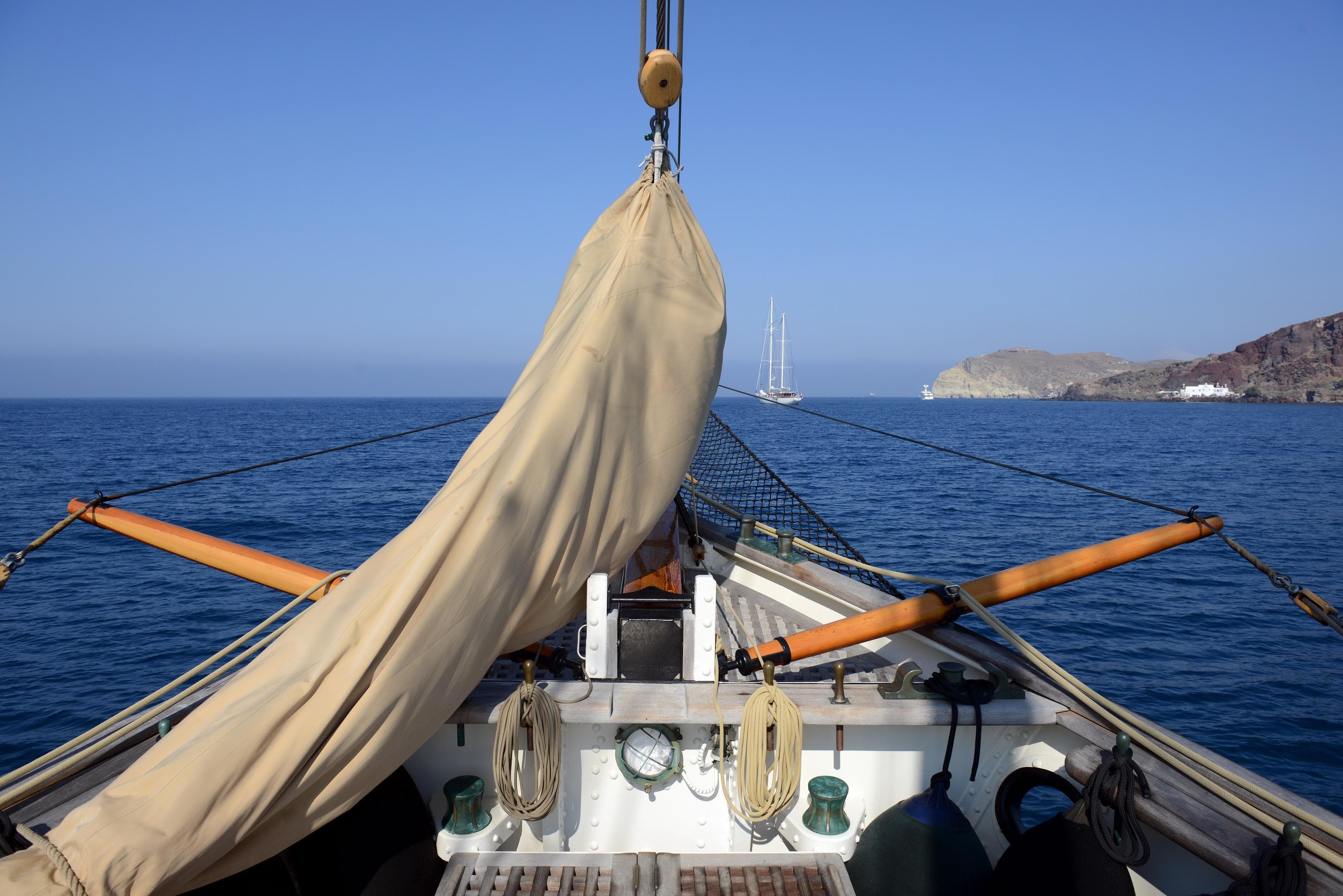 1920 J.P. Smit Motorsailer Schooner sailing on calm blue sea near rocky coastline.