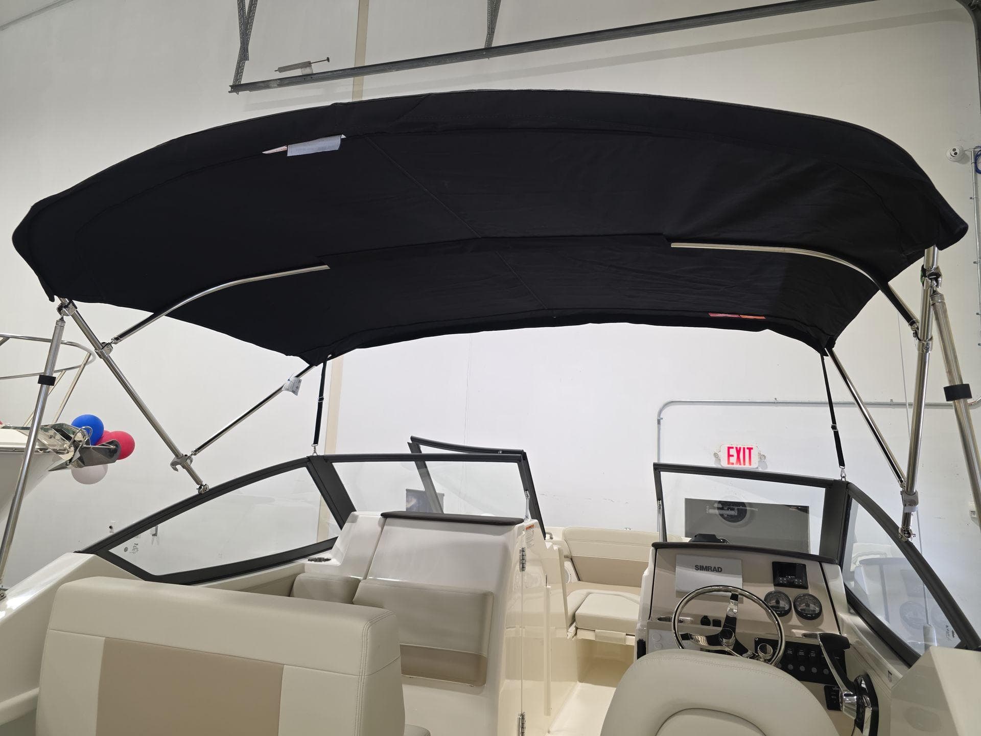 2025 Boston Whaler 210 Vantage boat interior with black canopy and steering console.