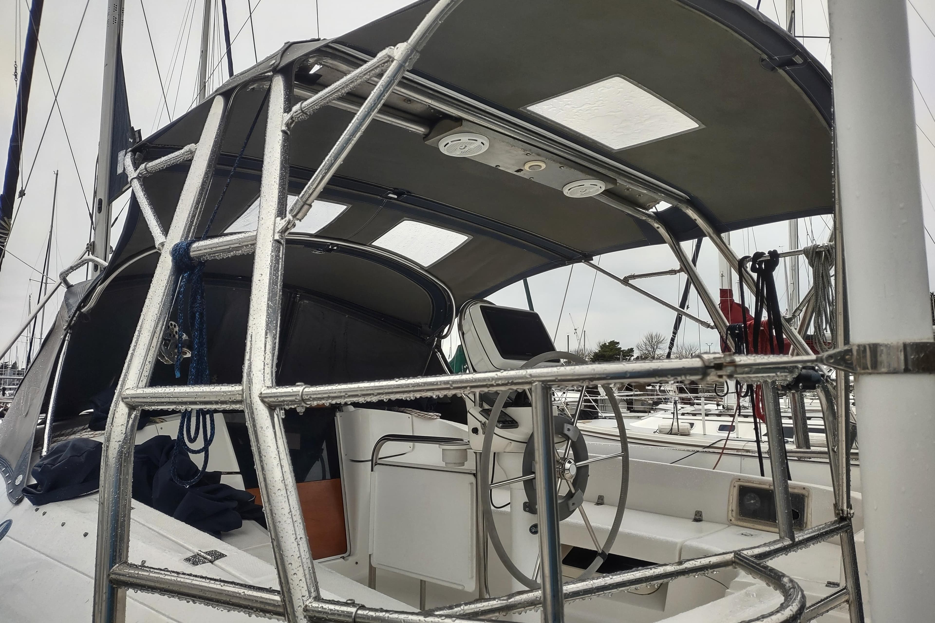2003 Hunter 356 sailboat cockpit with steering wheel and protective canopy.