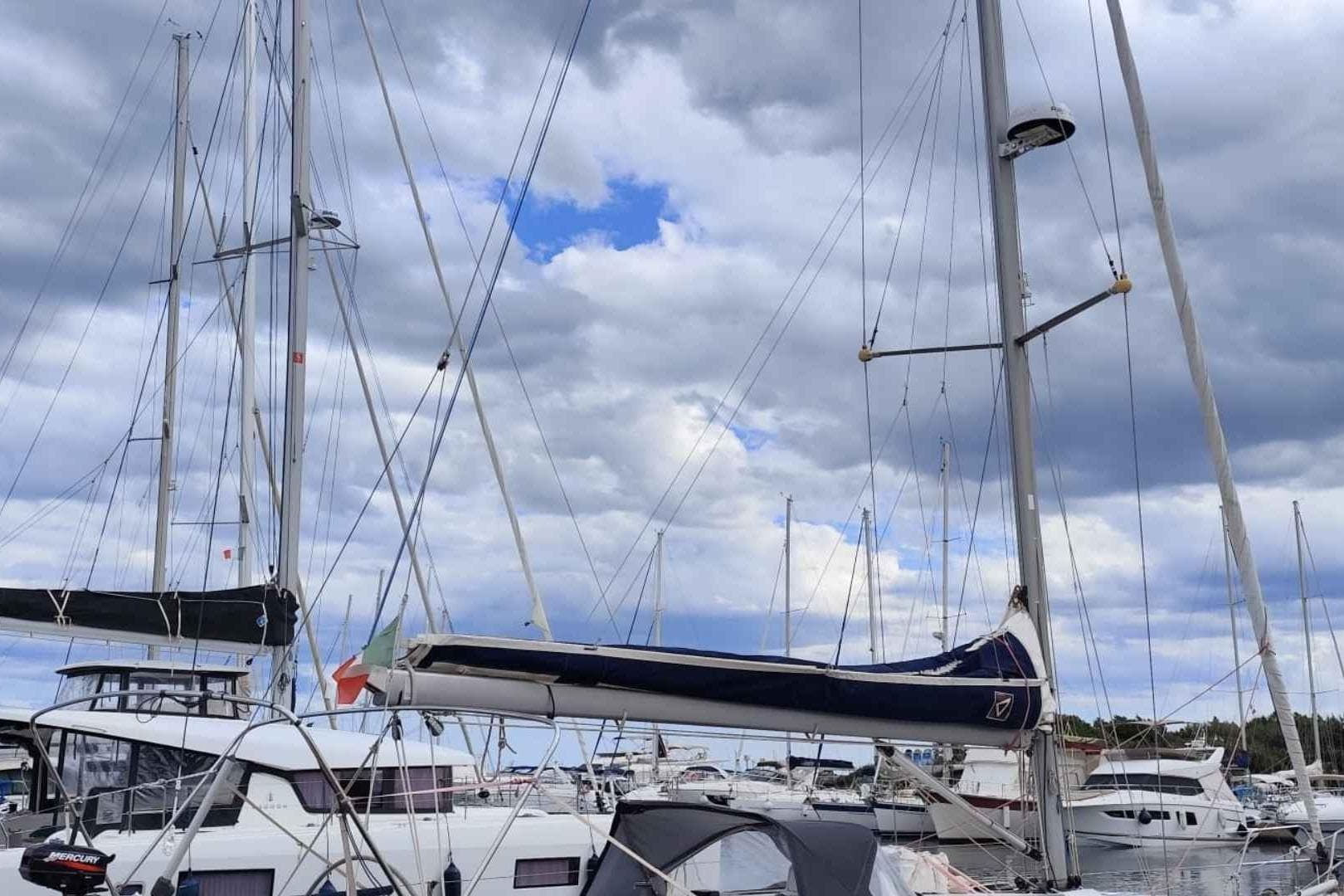 Sailboats docked at marina under cloudy sky, featuring a 2000 Dehler 39.