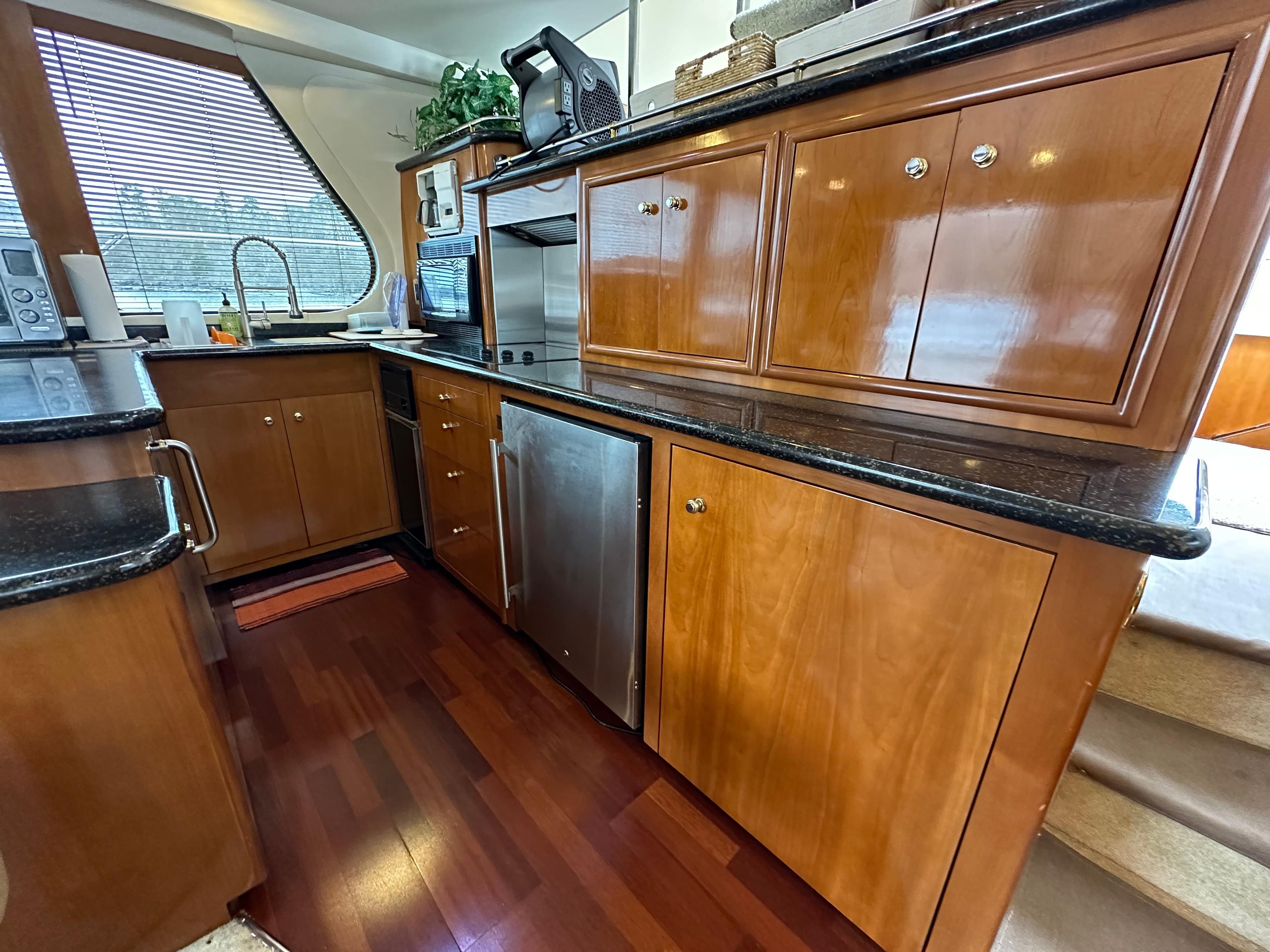 Luxurious kitchen area in a 2001 Carver 570 Voyager Pilothouse yacht with wooden cabinetry.