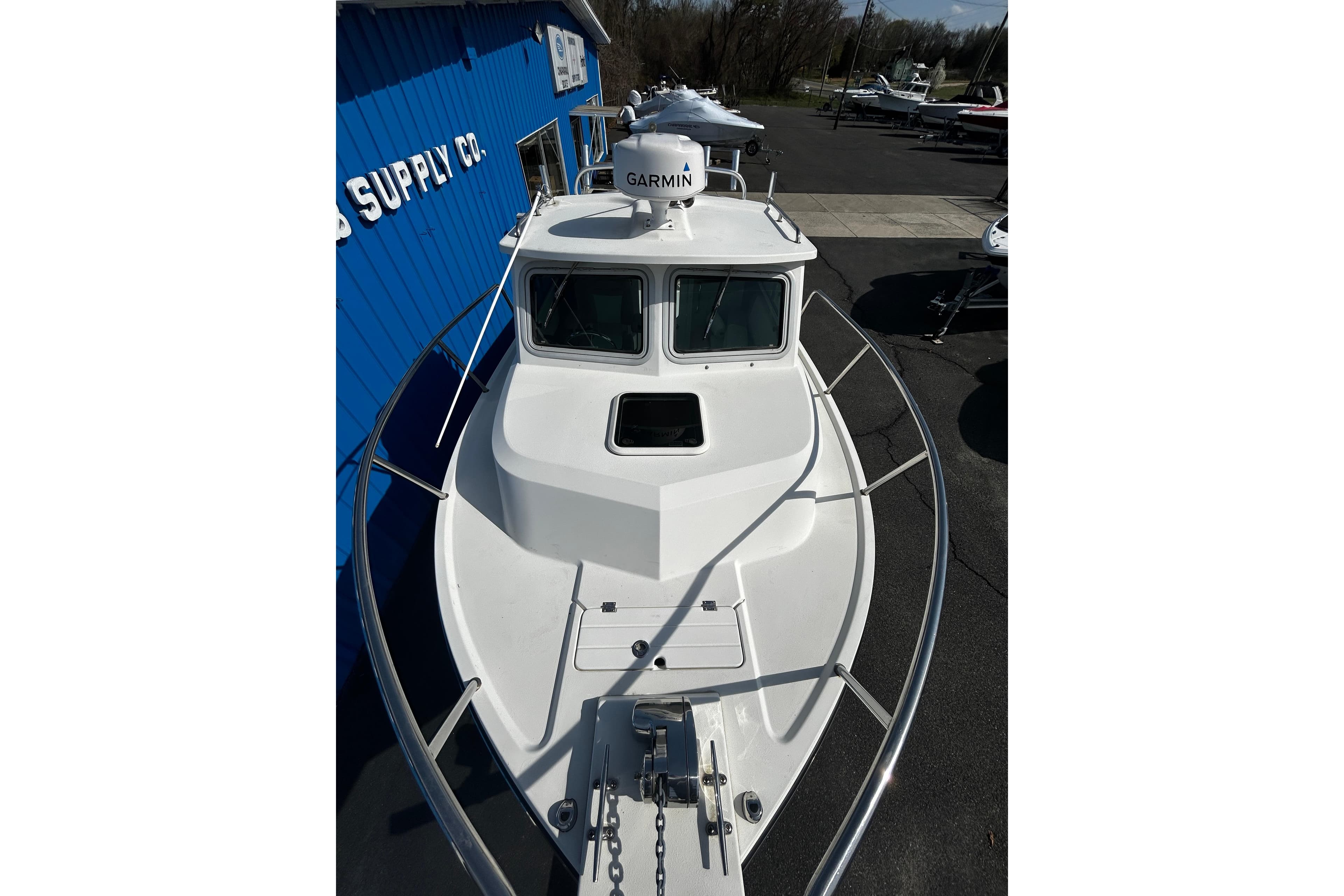2019 Parker 2320 Sport Cabin boat with Garmin radar, docked near blue building.
