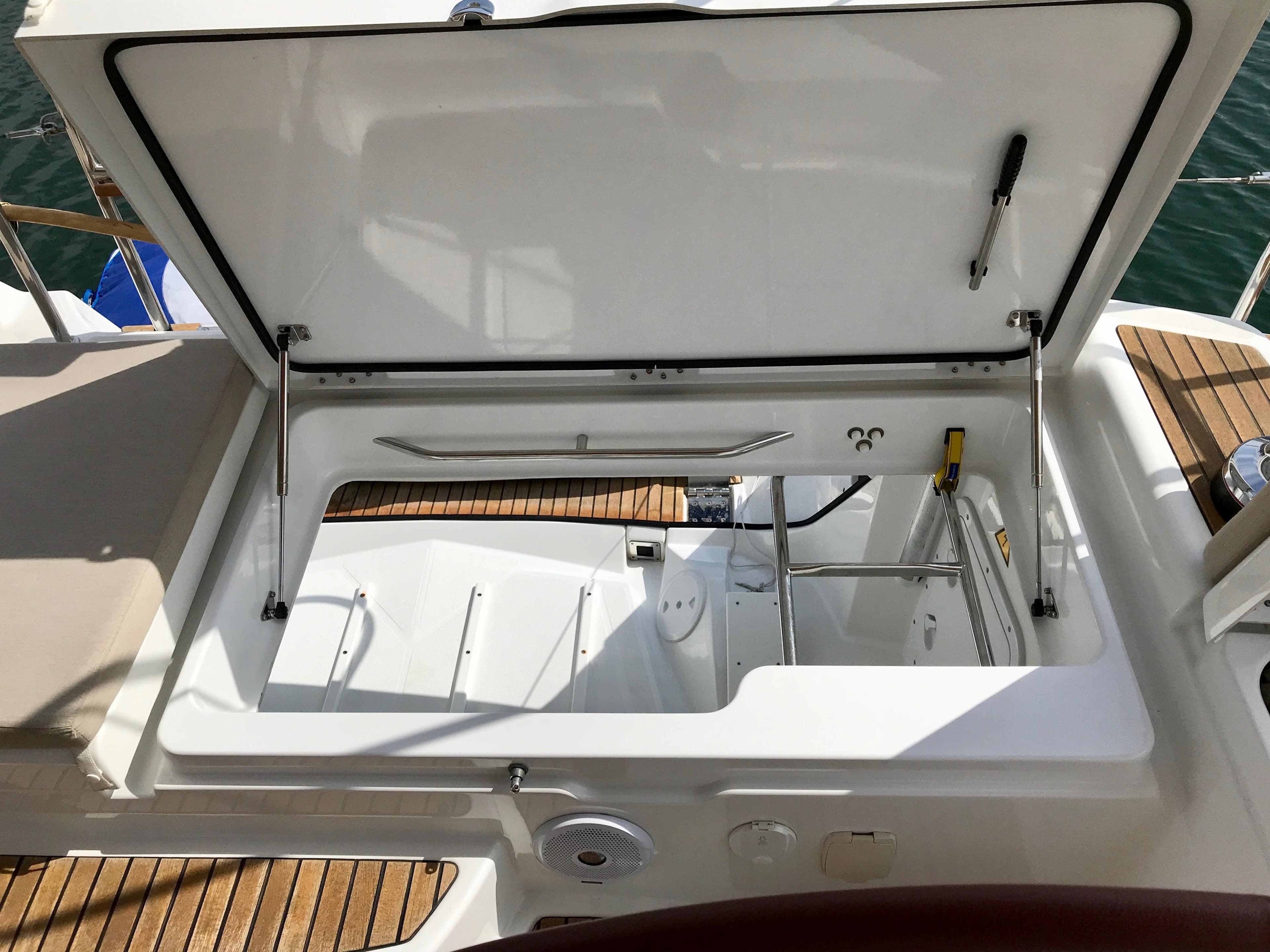Open storage compartment on 2014 Jeanneau 57 yacht with teak decking.