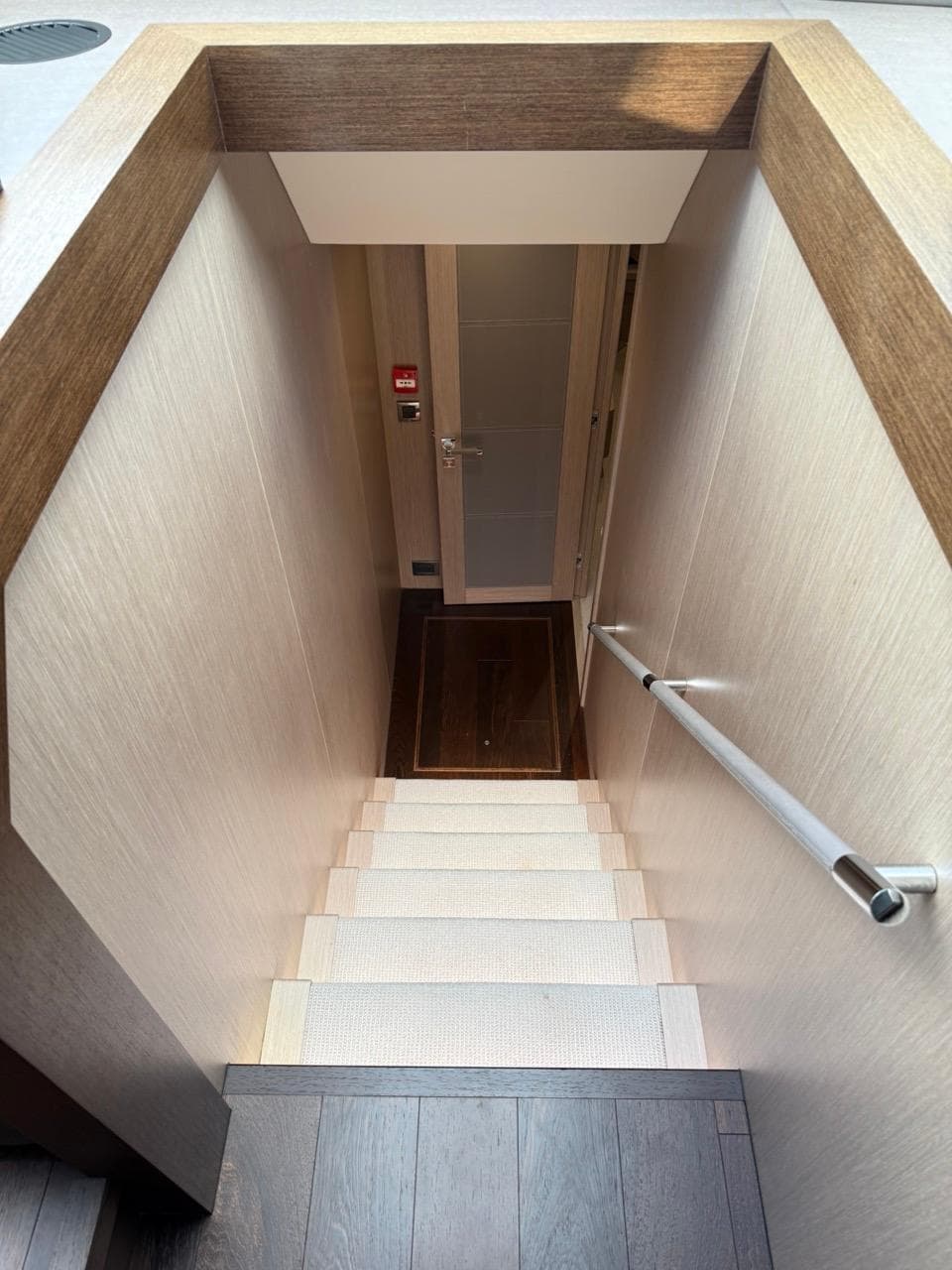 Staircase inside 2018 Sunseeker 86 Yacht, featuring sleek wooden design and modern handrail.