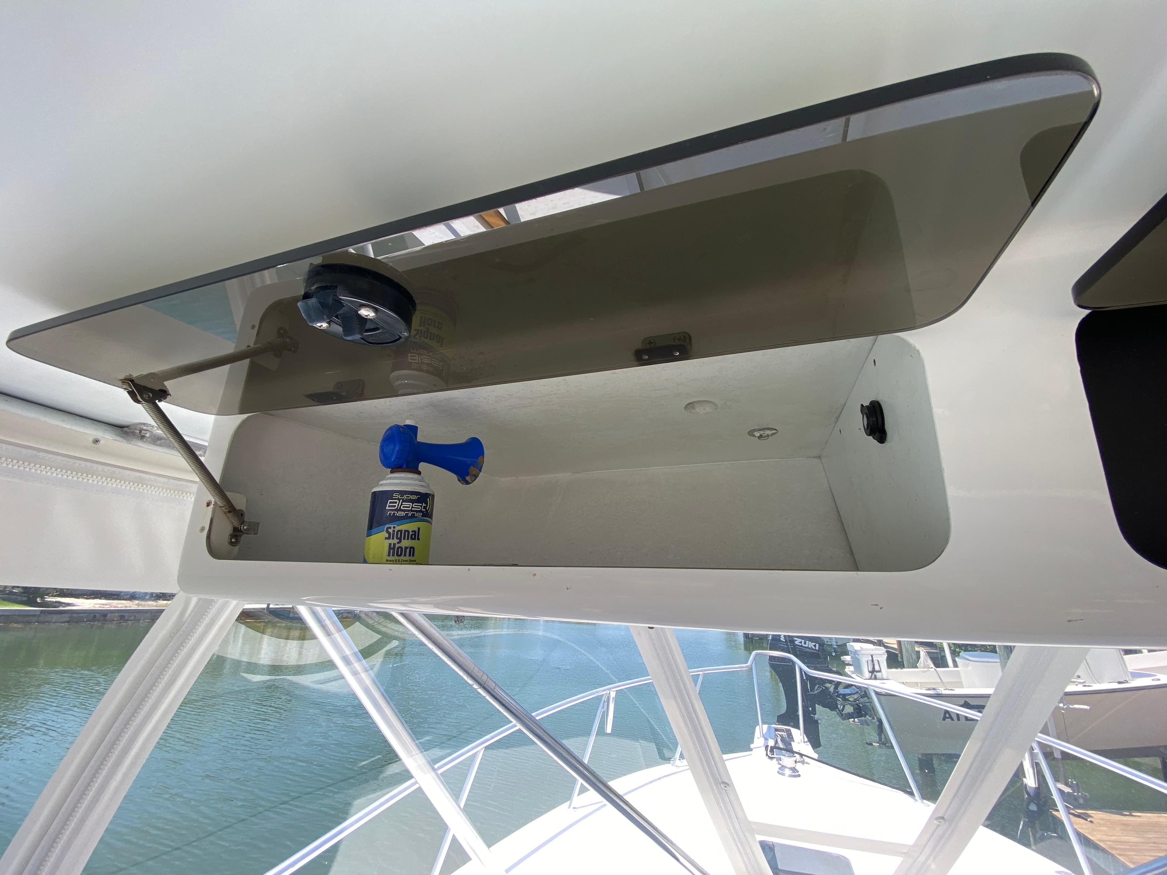Open storage compartment on 1995 L&H 33 boat with signal horn inside.