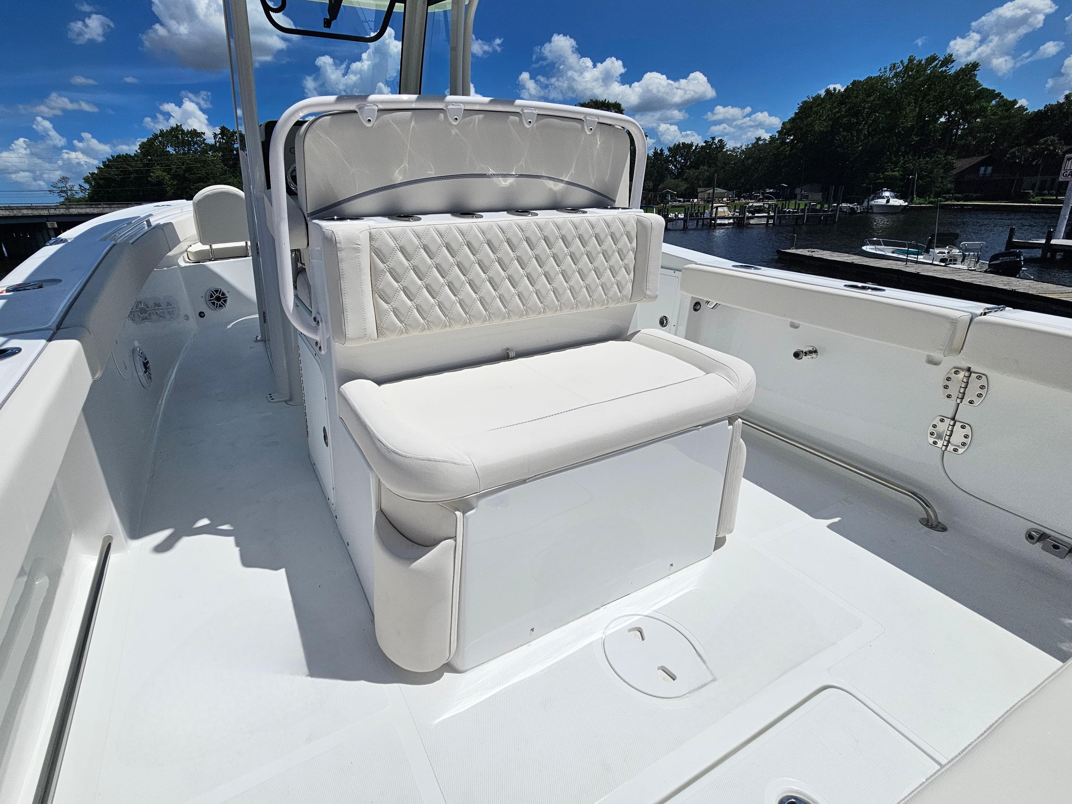 2026 Sea Hunt Ultra 275 SE boat interior with white cushioned seating under a clear blue sky.