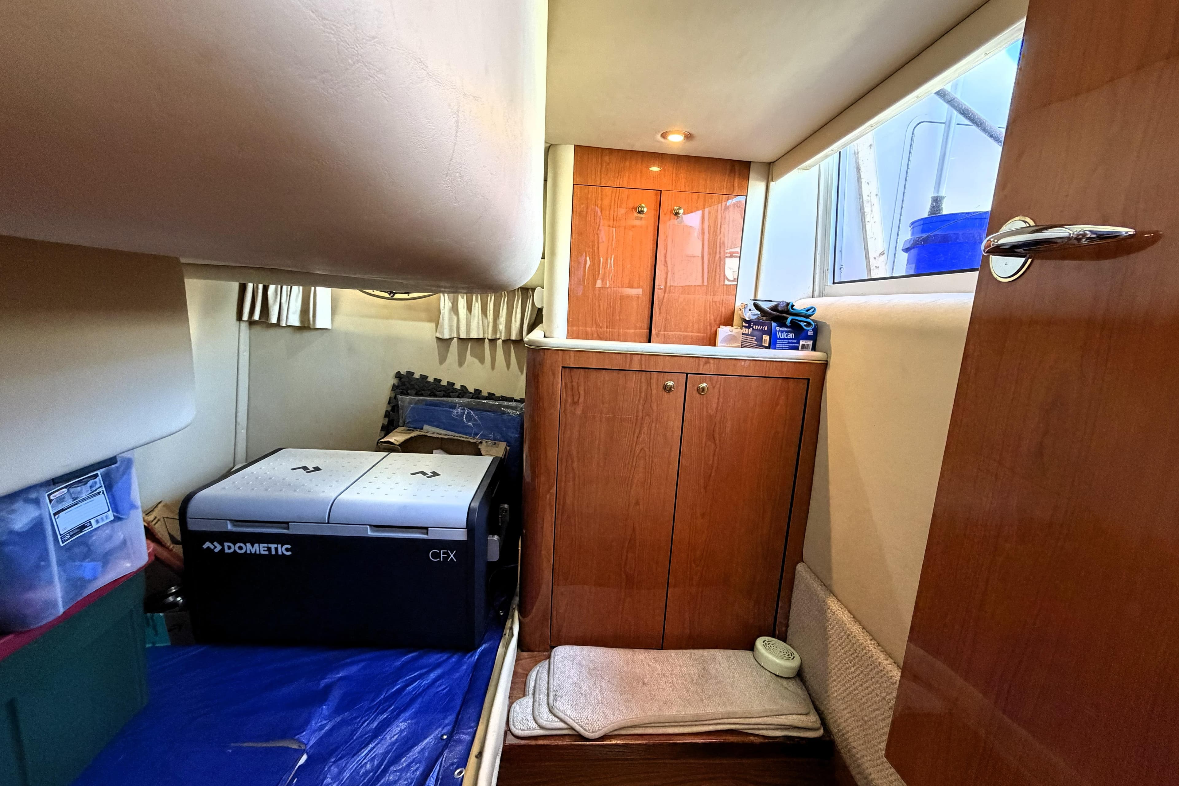 Interior cabin of a 2000 Sea Ray 450 Express Bridge with storage and Dometic cooler.