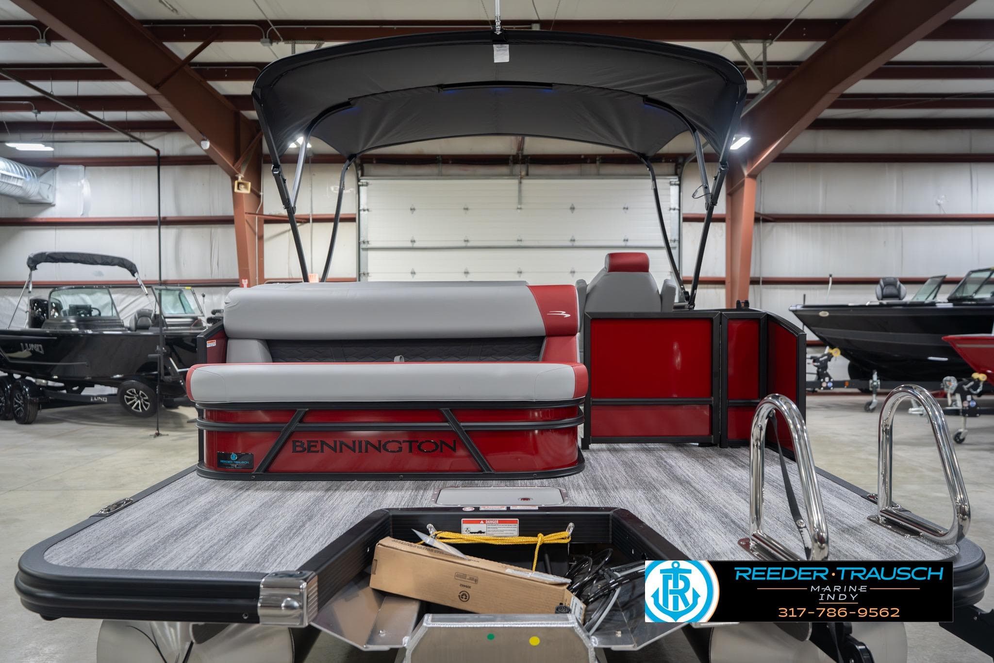 2026 Bennington 22 SLJ pontoon boat in showroom, featuring sleek design and modern seating.