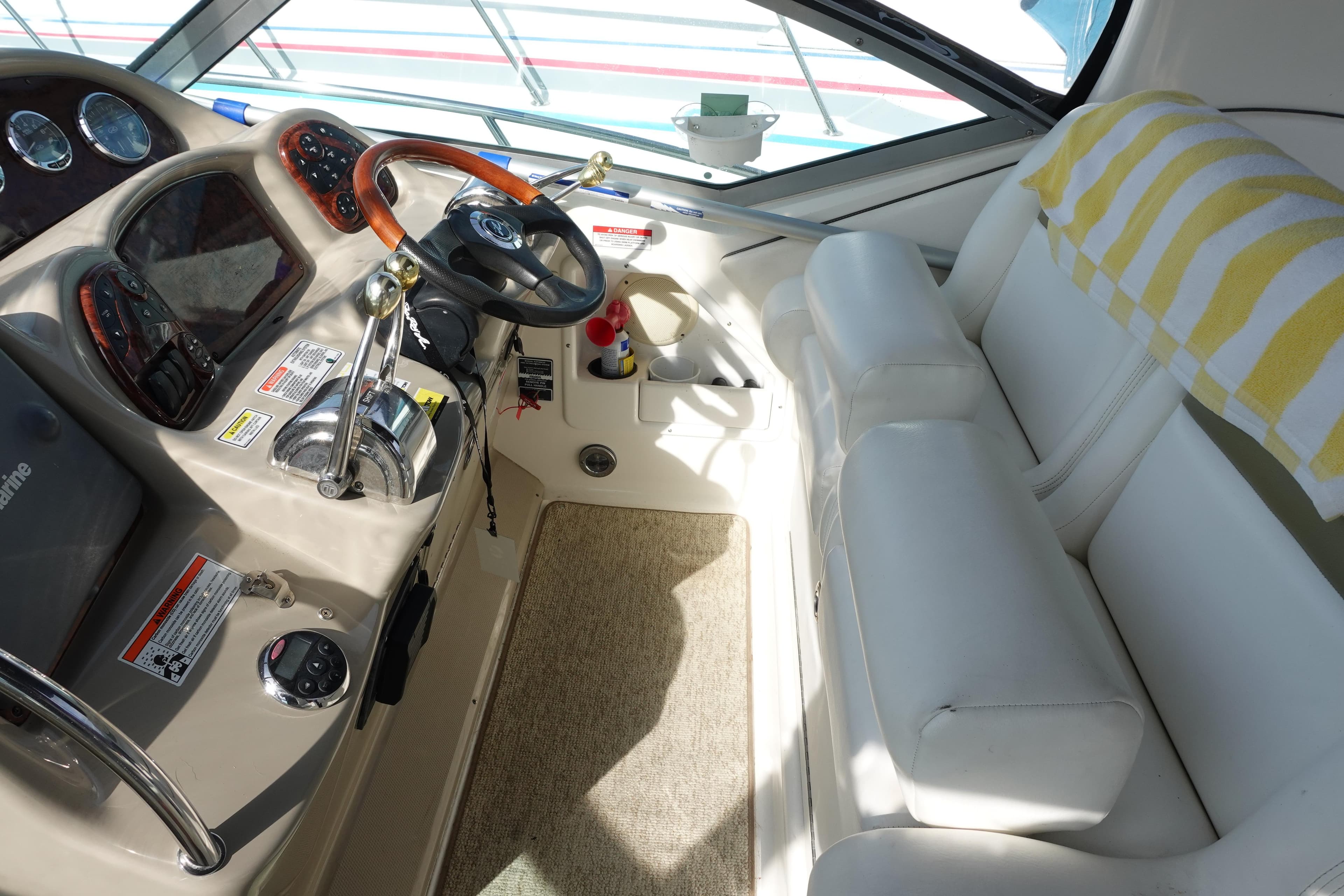 2007 Sea Ray 320 Sundancer cockpit with steering wheel, controls, and white seating.