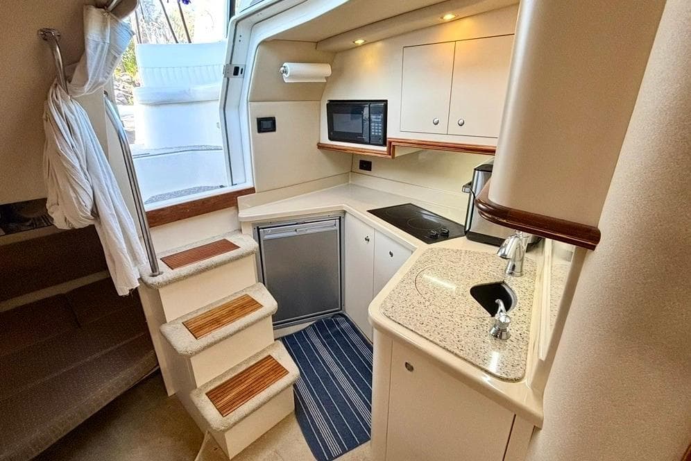 2003 Cruisers Yachts 3470 Express interior kitchen with modern amenities and compact design.