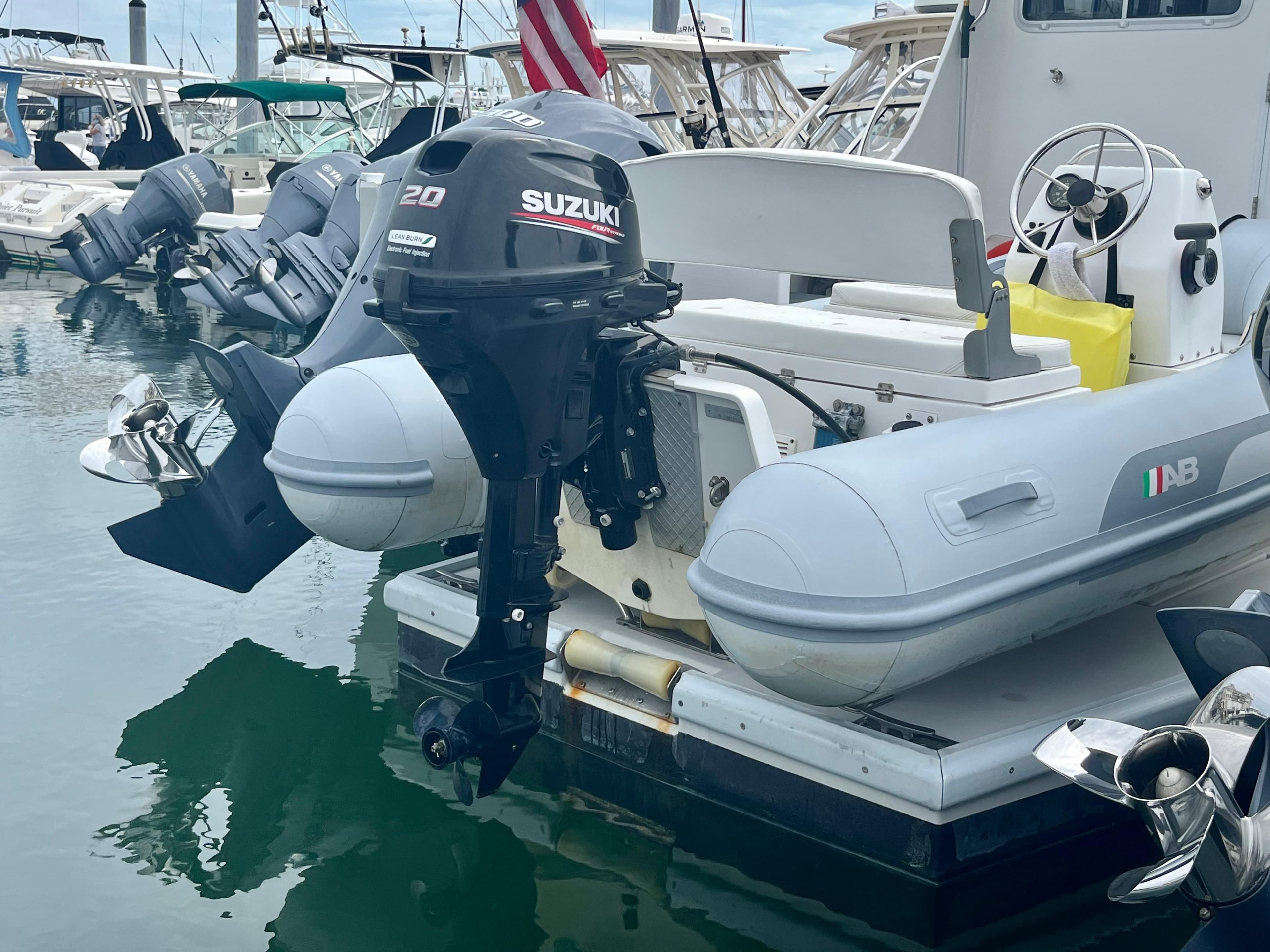 Inflatable boat with Suzuki outboard motor docked near Wesmac 42, 2016 model.