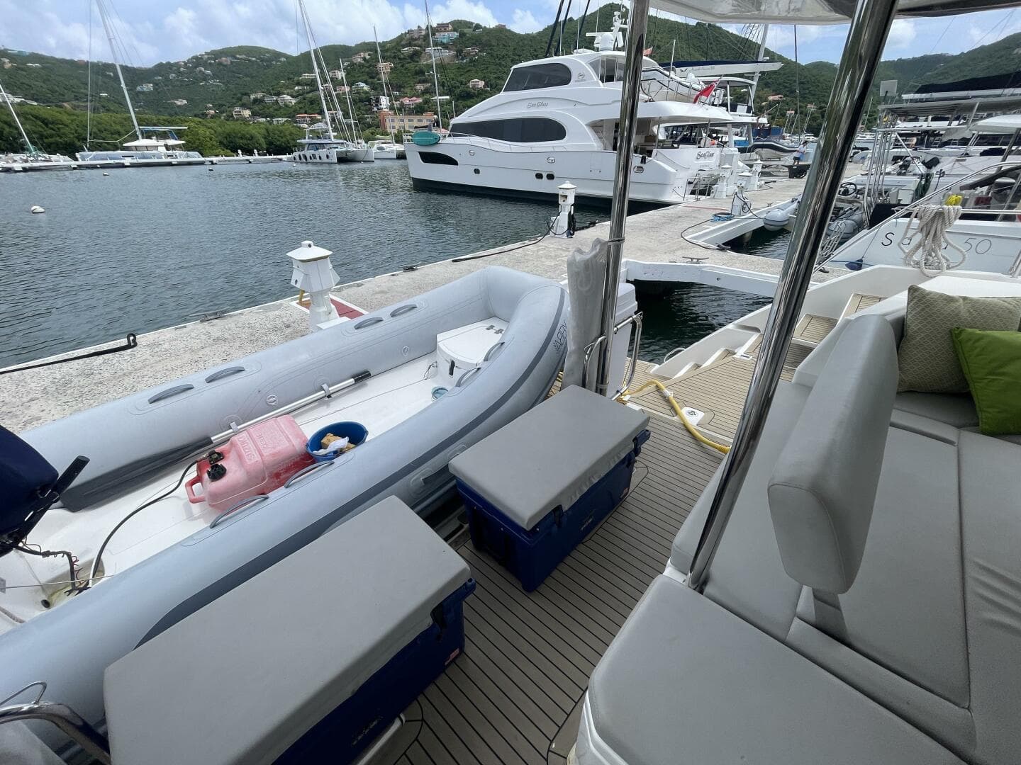 A Leopard 50 yacht docked at a marina with inflatable boat and scenic background.