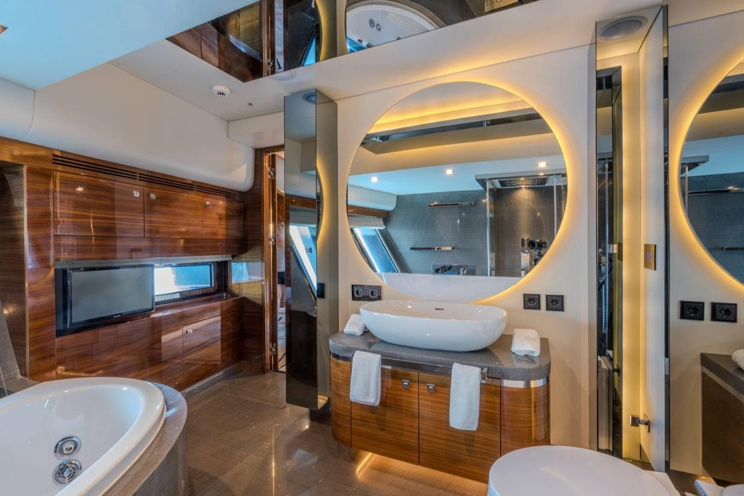 Luxurious yacht bathroom with modern design, featuring a round mirror and elegant wood finishes. Royal Craft 45, 2012.