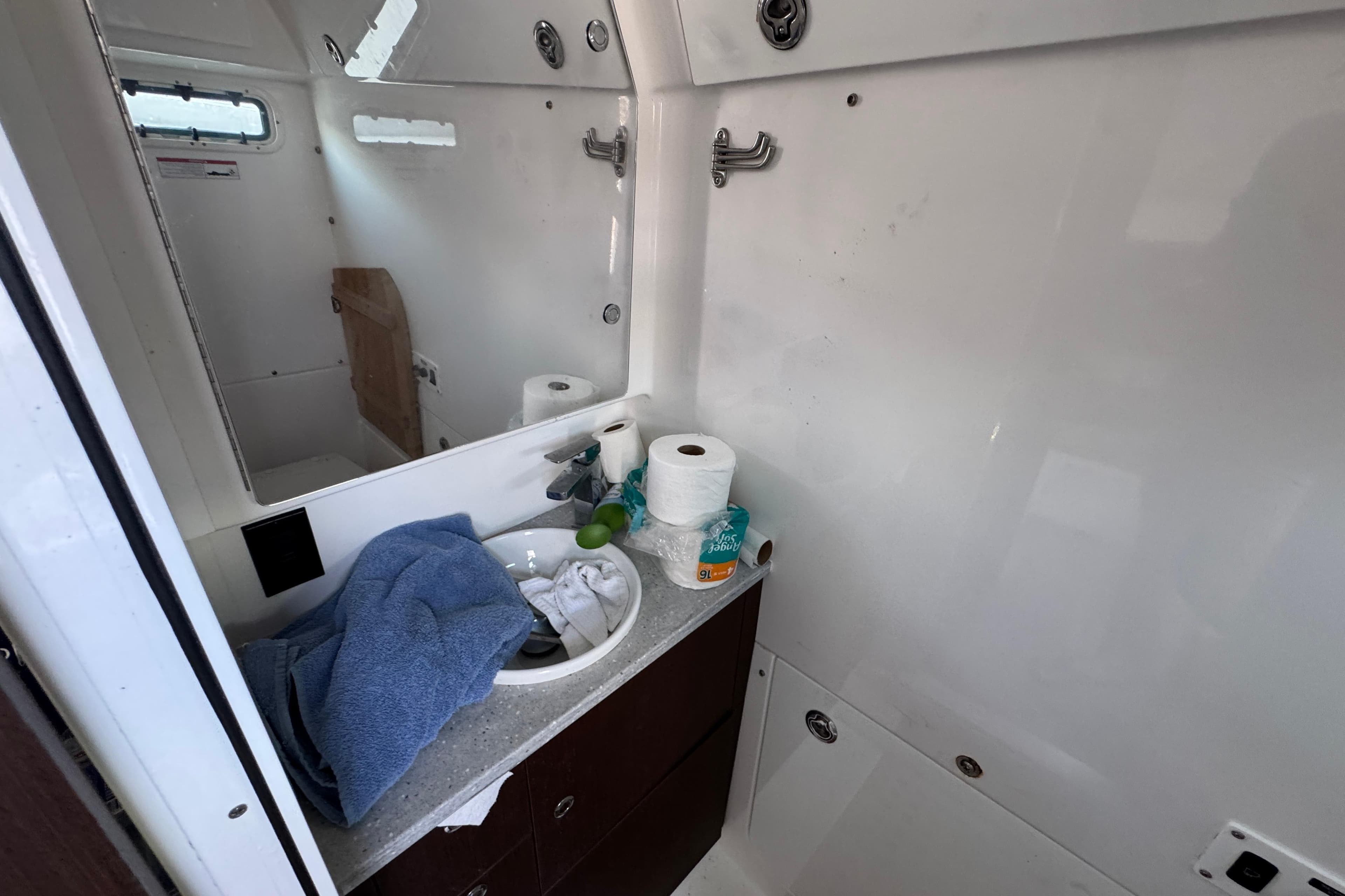 Interior of 2022 Everglades 395 Center Console boat bathroom with sink and toiletries.