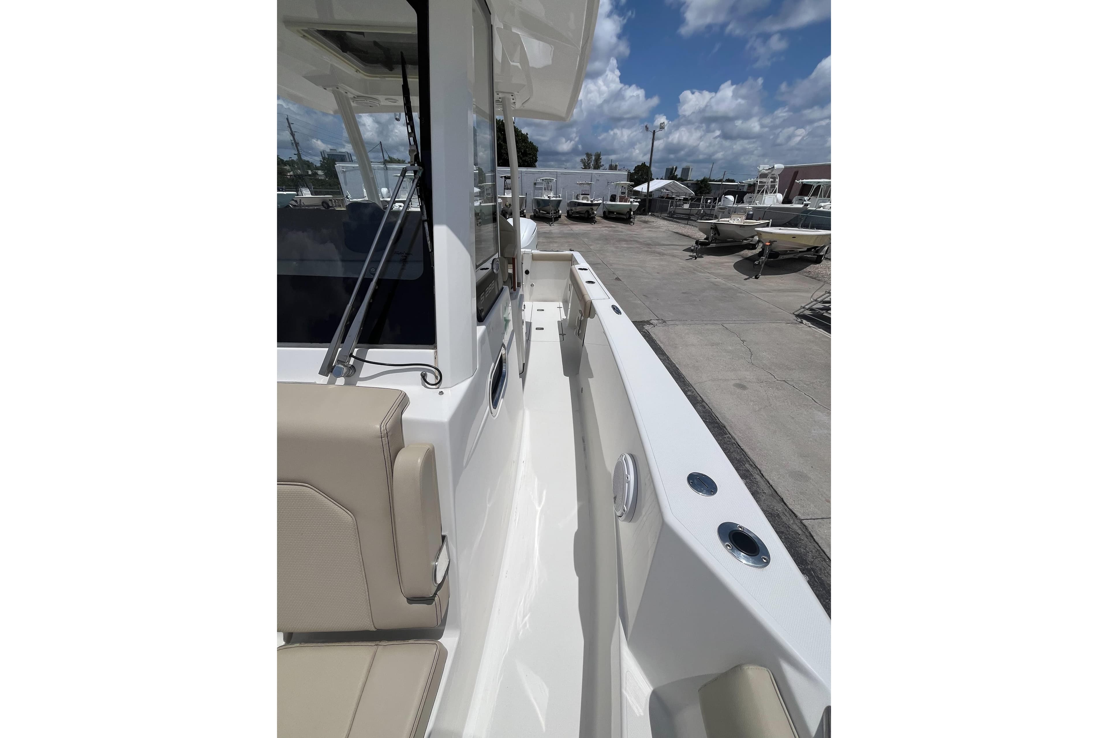 2019 Pursuit S 288 Sport boat deck with beige seating and clear sky.
