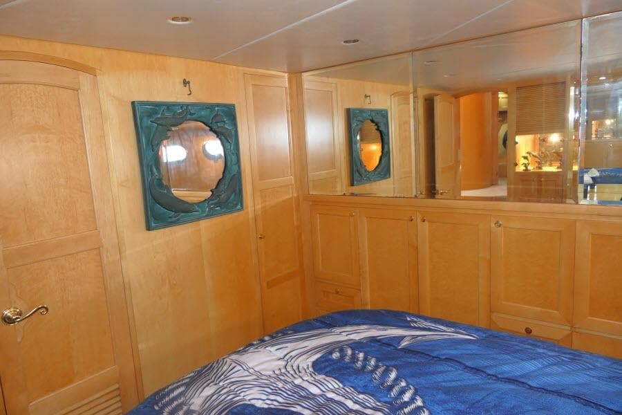 Luxurious cabin interior of 1999 Hampton 490 Pilothouse yacht with wood paneling and nautical decor.