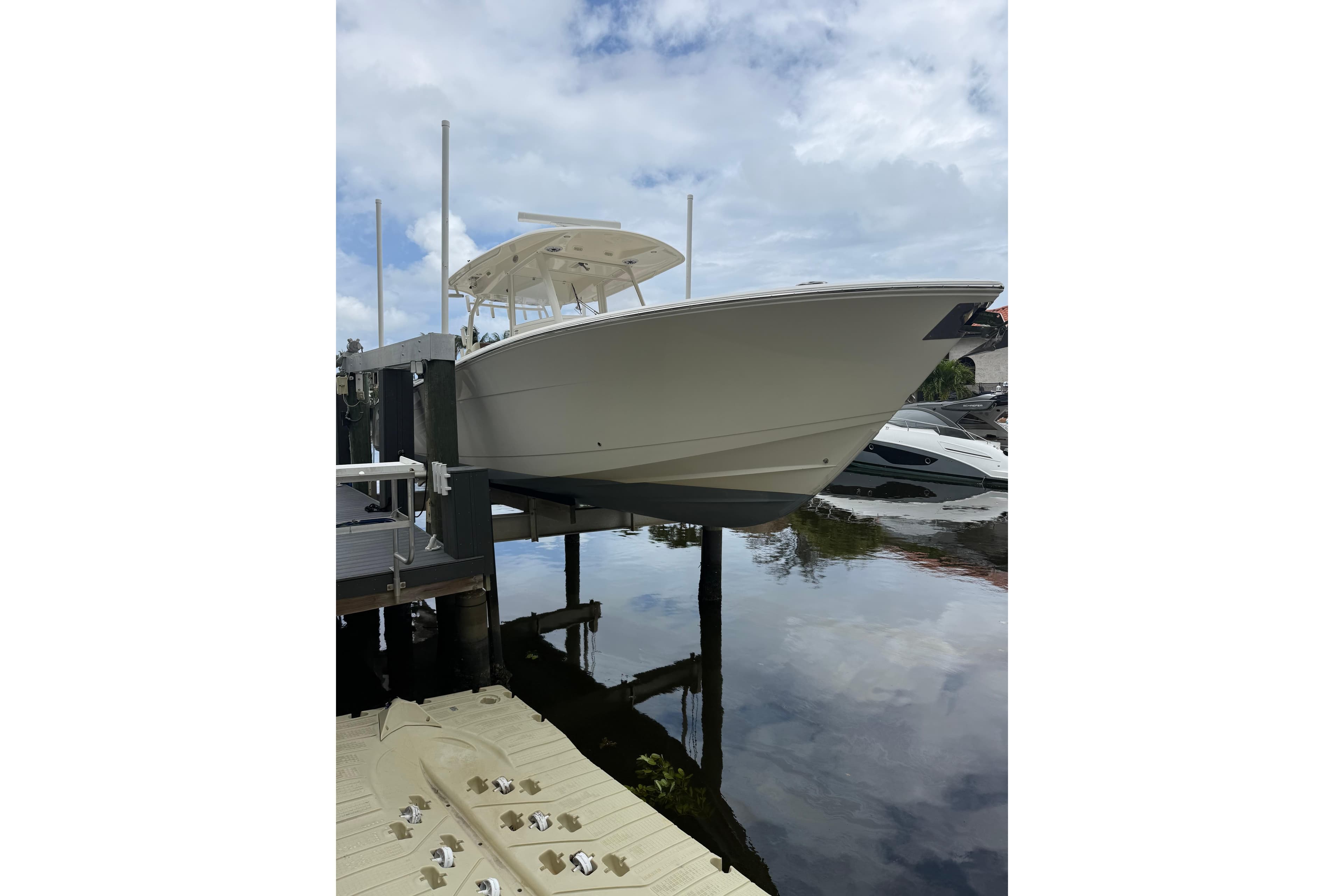 2020 Cobia 350 Center Console boat docked on a lift by the water.