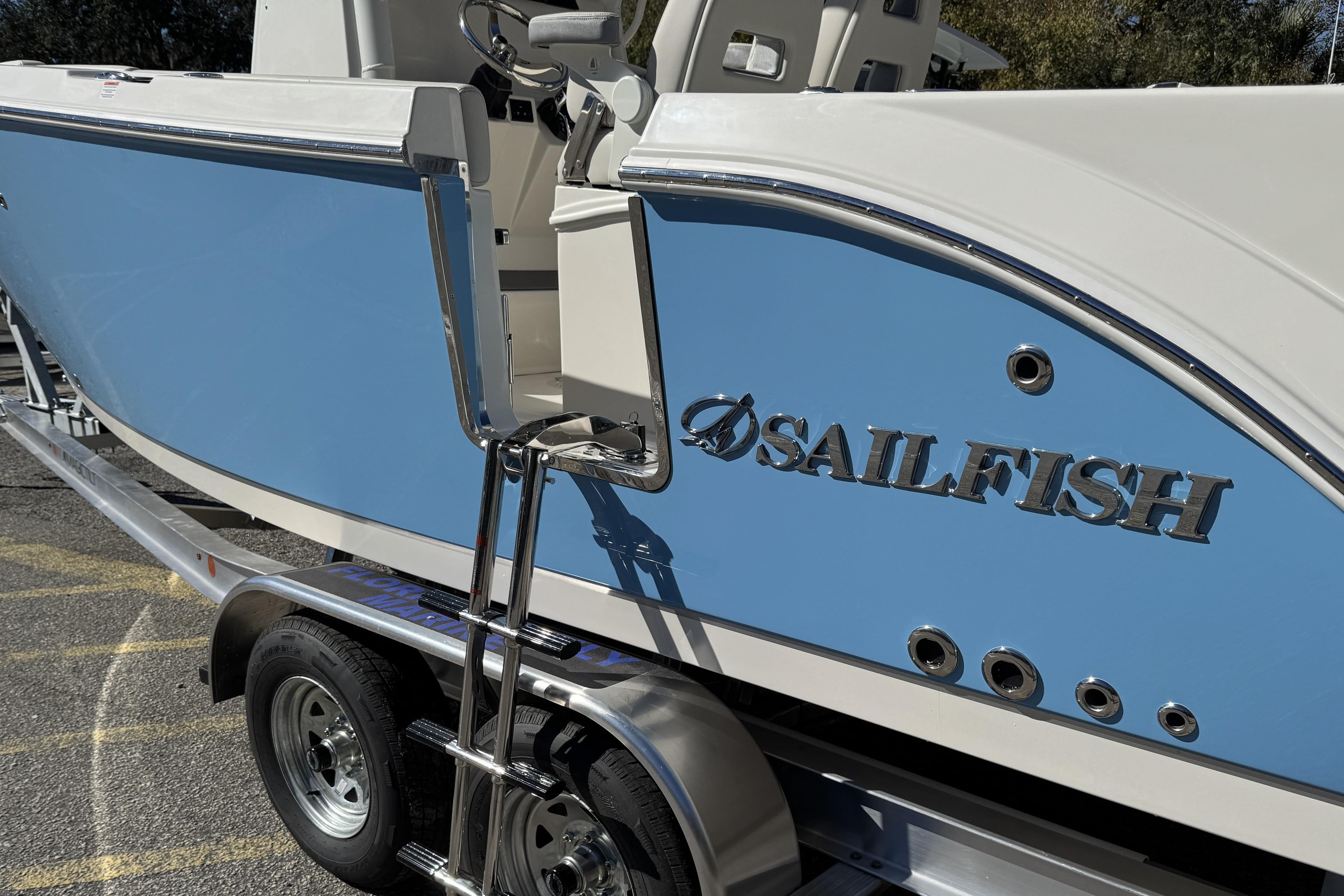 2026 Sailfish 252 CC boat on trailer, featuring blue and white design.