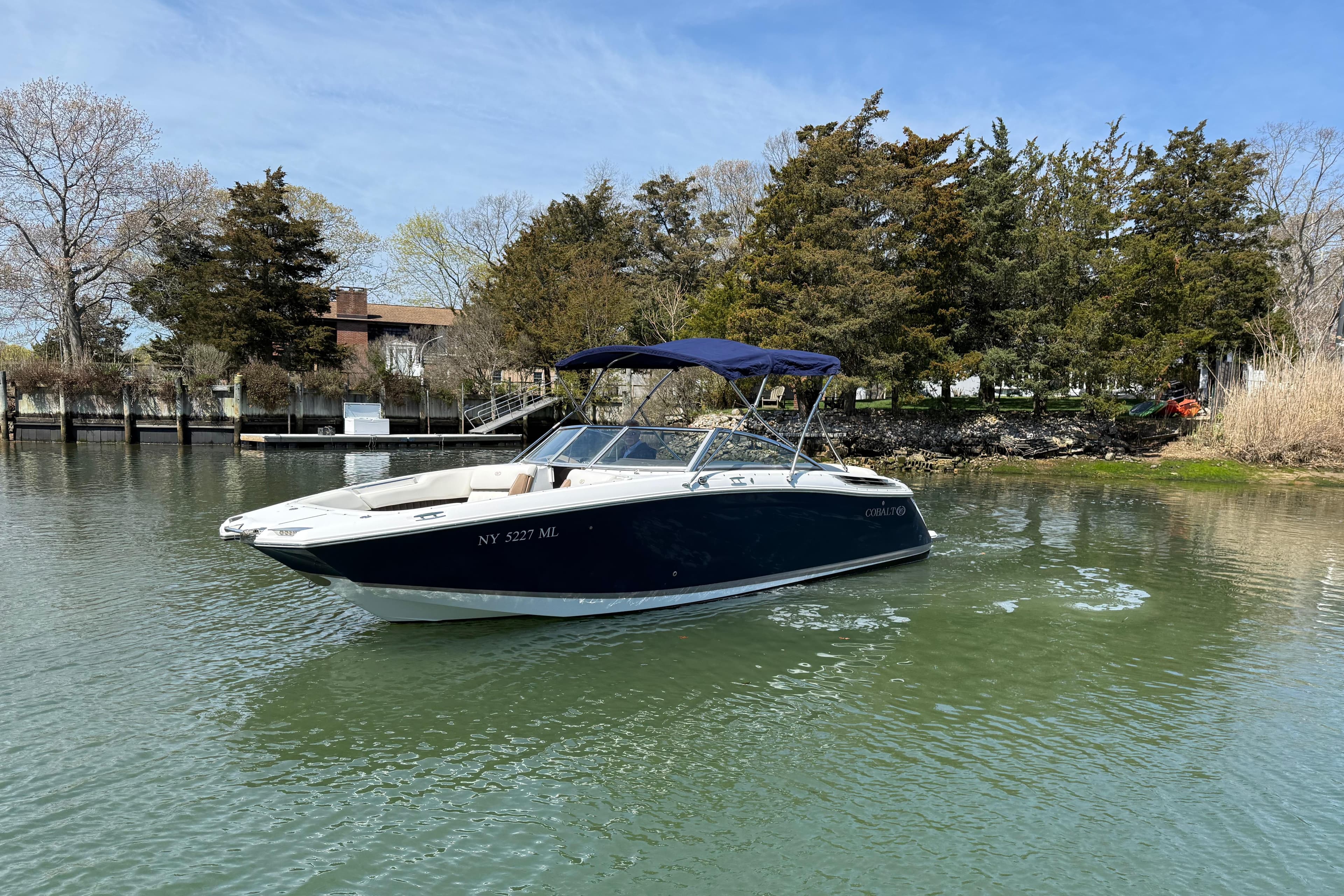 2015 Cobalt 26SD boat on calm water with trees in the background.