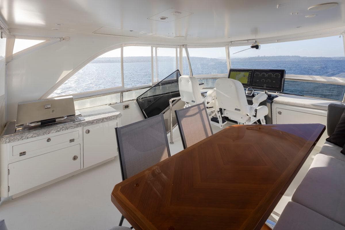 Luxurious 2017 Ocean Alexander 70e yacht interior with helm, dining area, and ocean view.