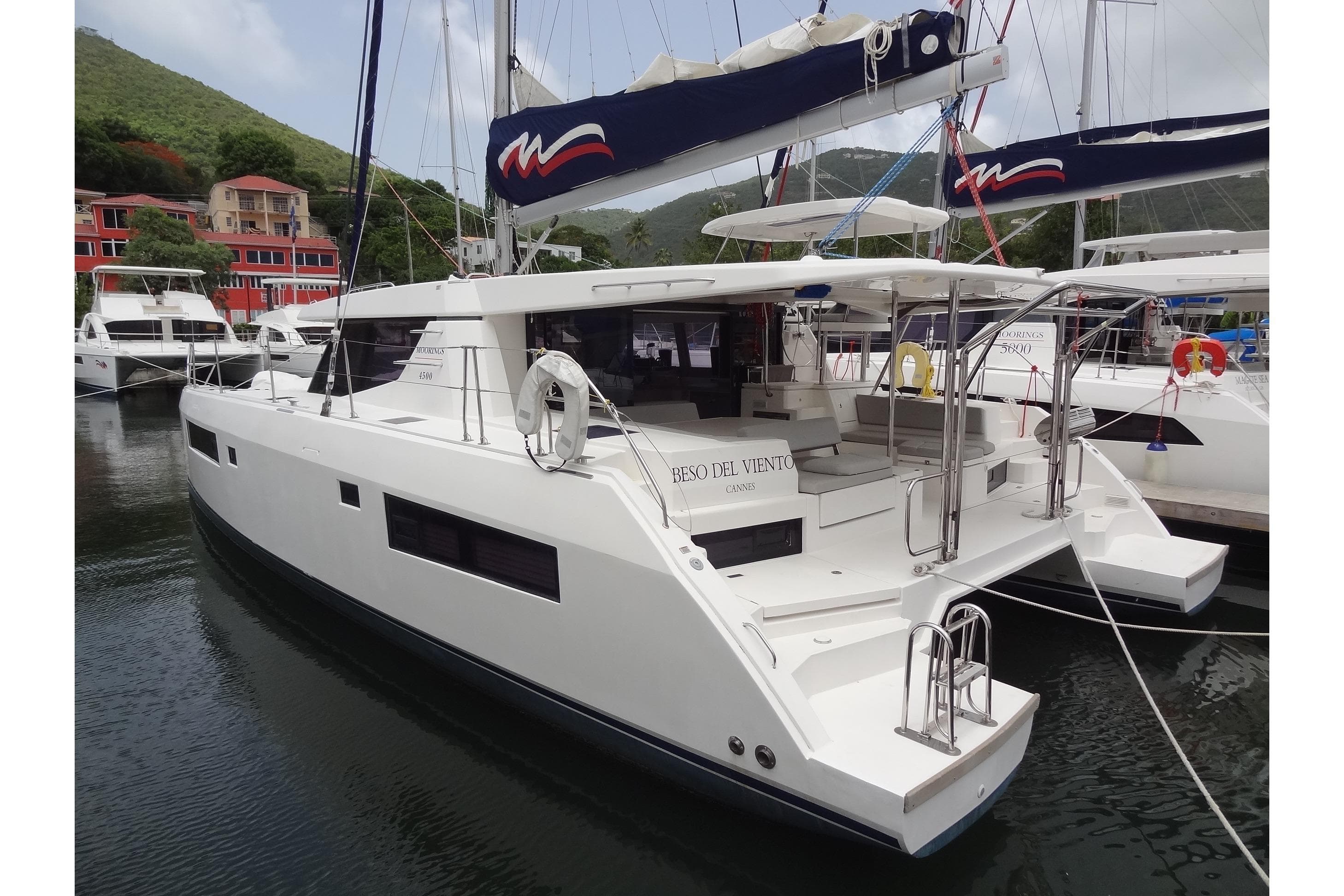 2020 Leopard 45 catamaran docked in marina, surrounded by lush green hills.
