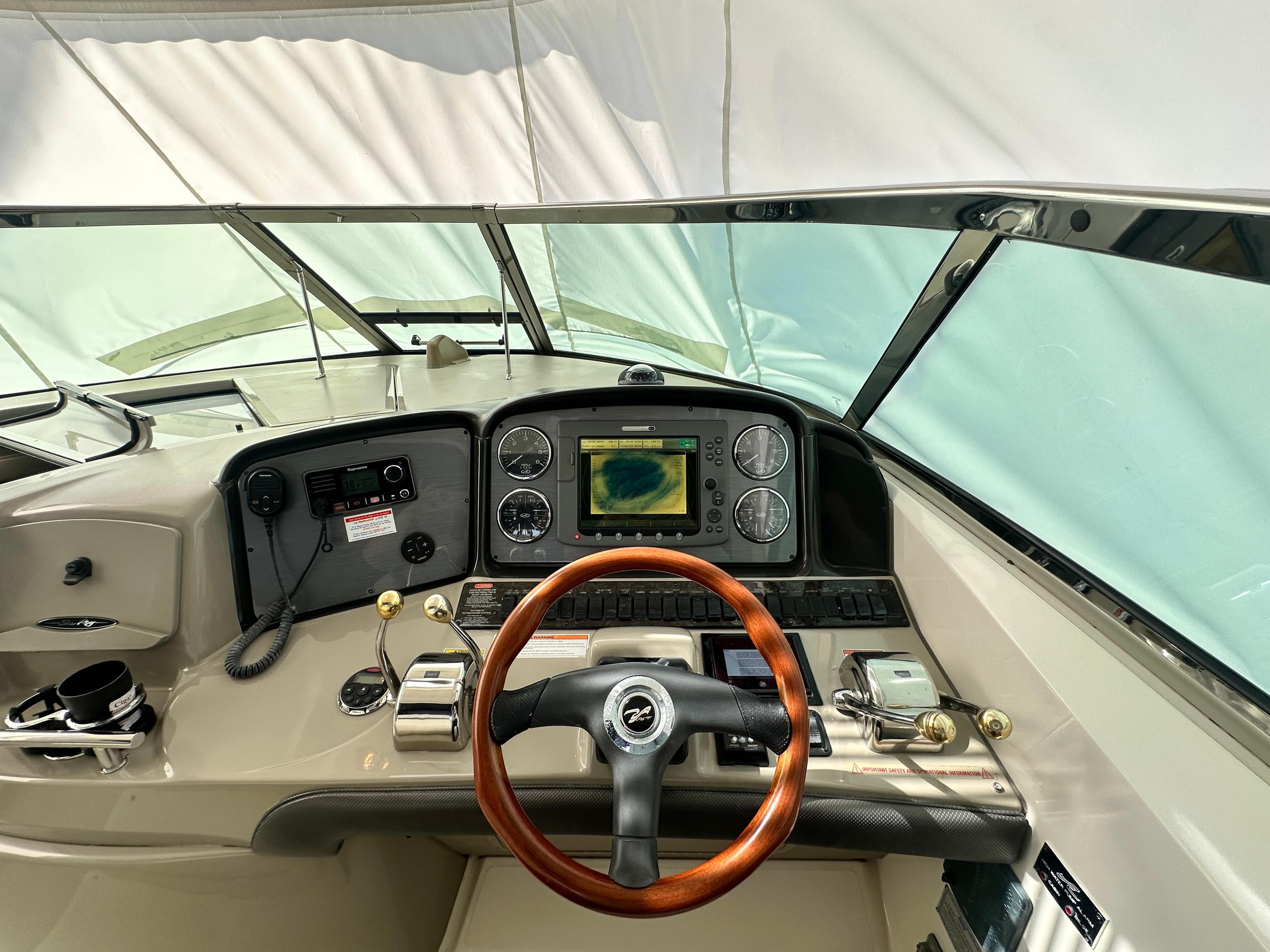 Helm of 2007 Sea Ray 380 Sundancer with wood steering wheel and navigation system.