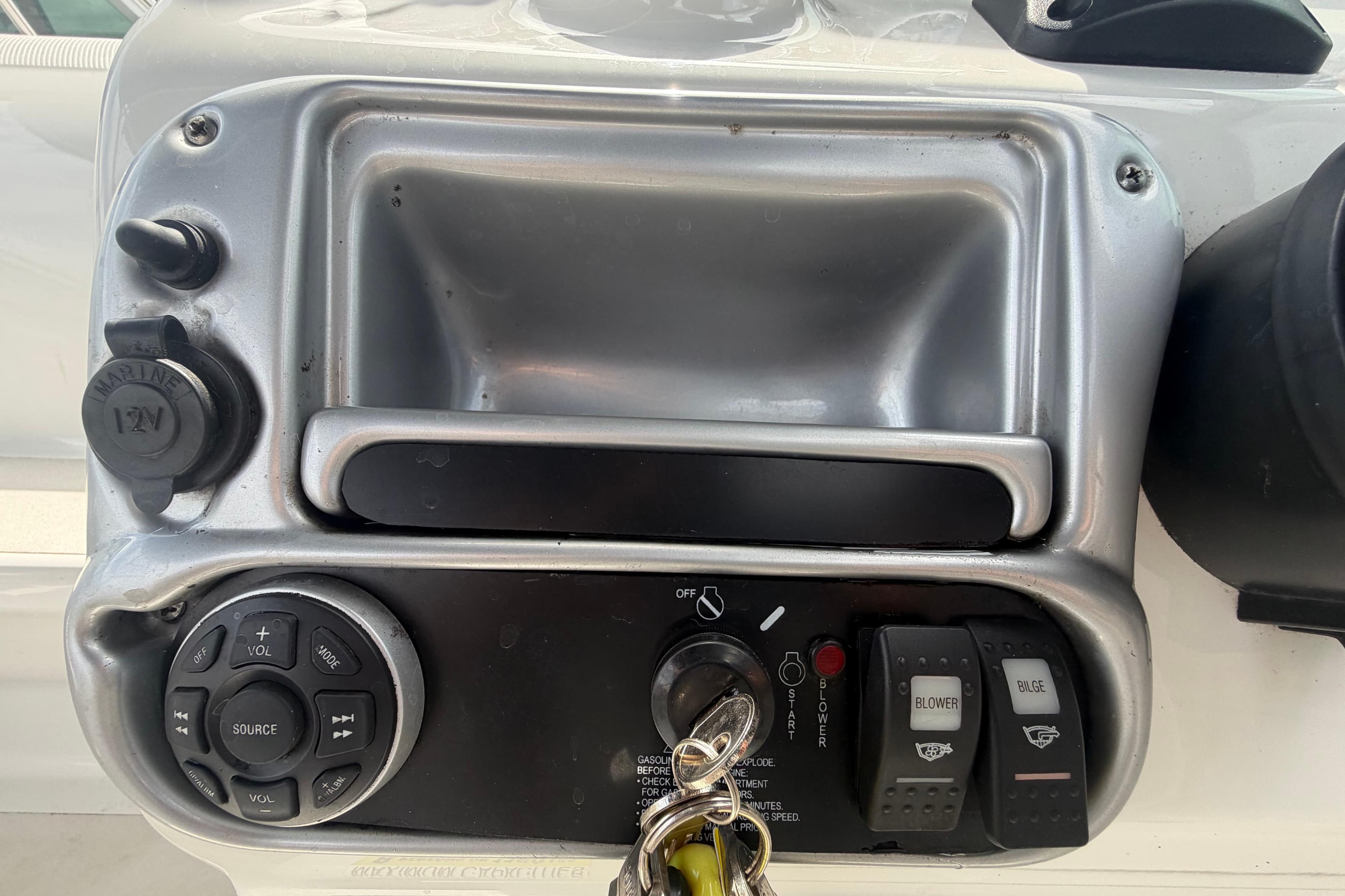Control panel of a 2012 Crownline 236 SC boat with switches and key ignition.