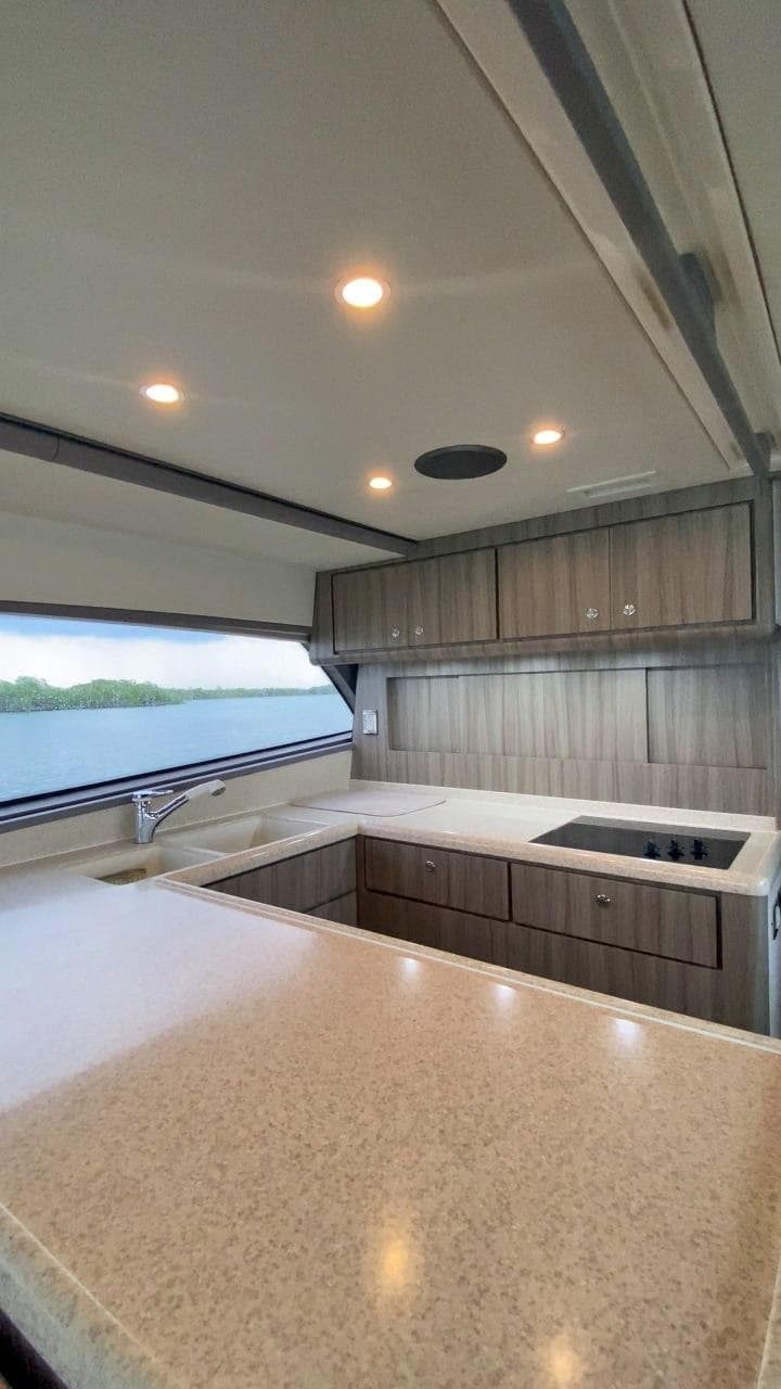 Modern kitchen interior of a 2004 Bertram 51 Convertible yacht with wood cabinets and ample counter space.