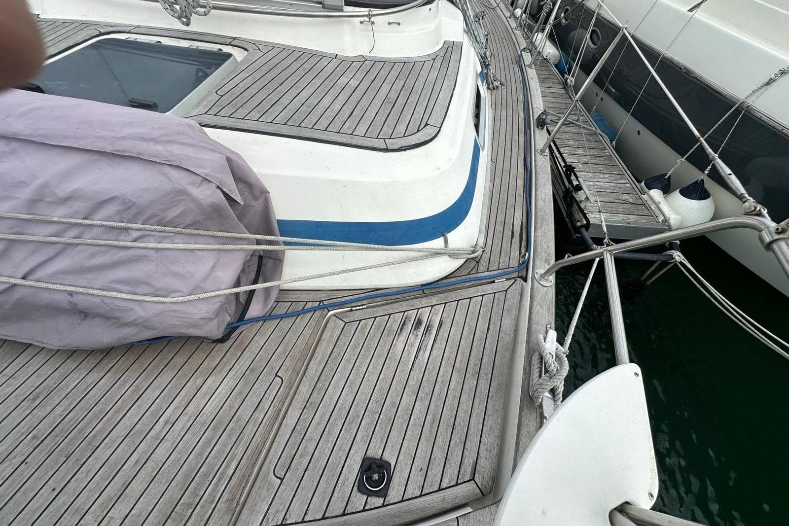 Deck of a 1999 Bavaria Yachts 38 Ocean, featuring wooden planks and rigging.
