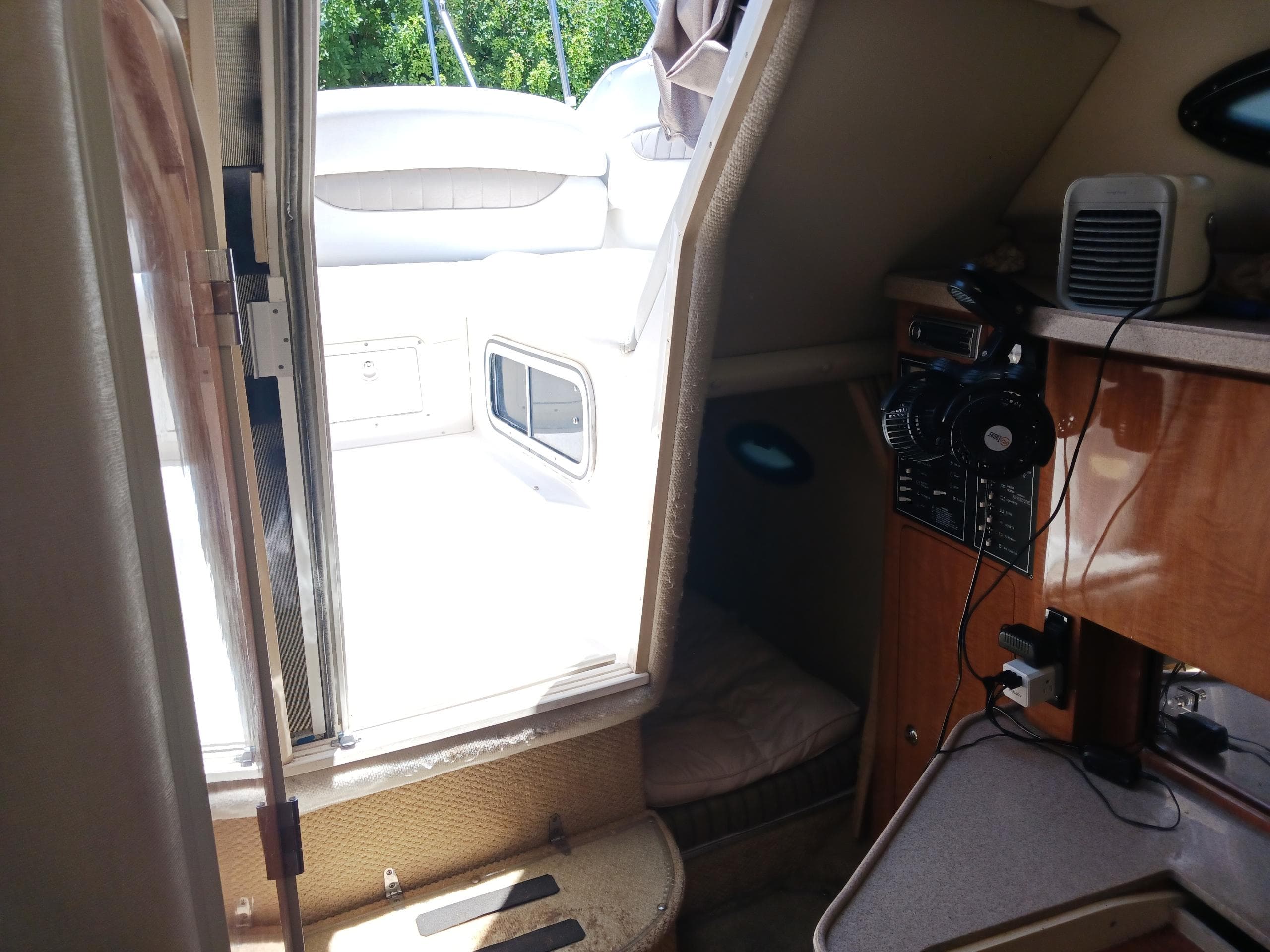 Interior view of 2004 Regal 2760 Commodore boat cabin with seating and control panel.