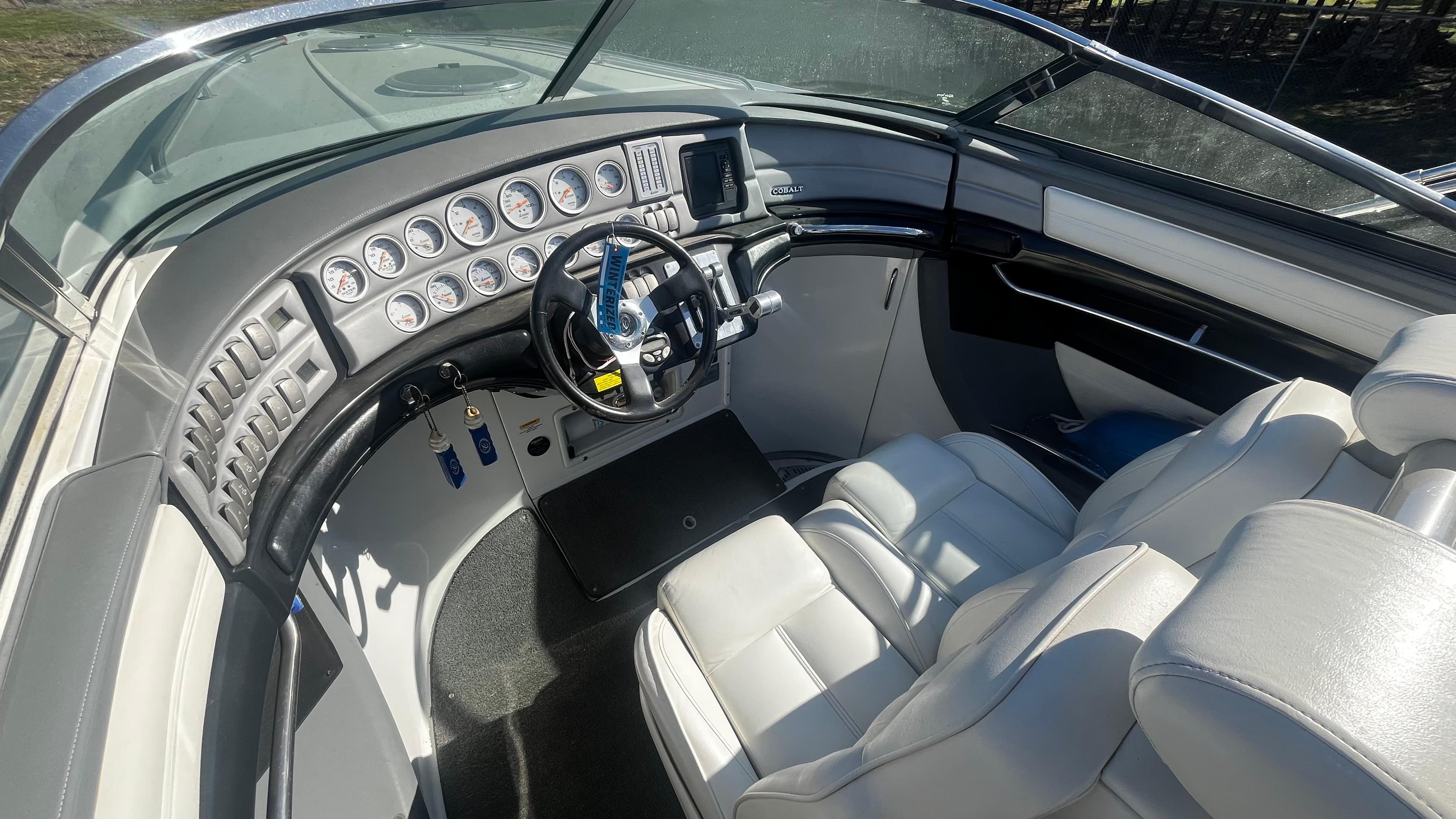 2005 Cobalt 343 boat interior with sleek dashboard and white leather seating.
