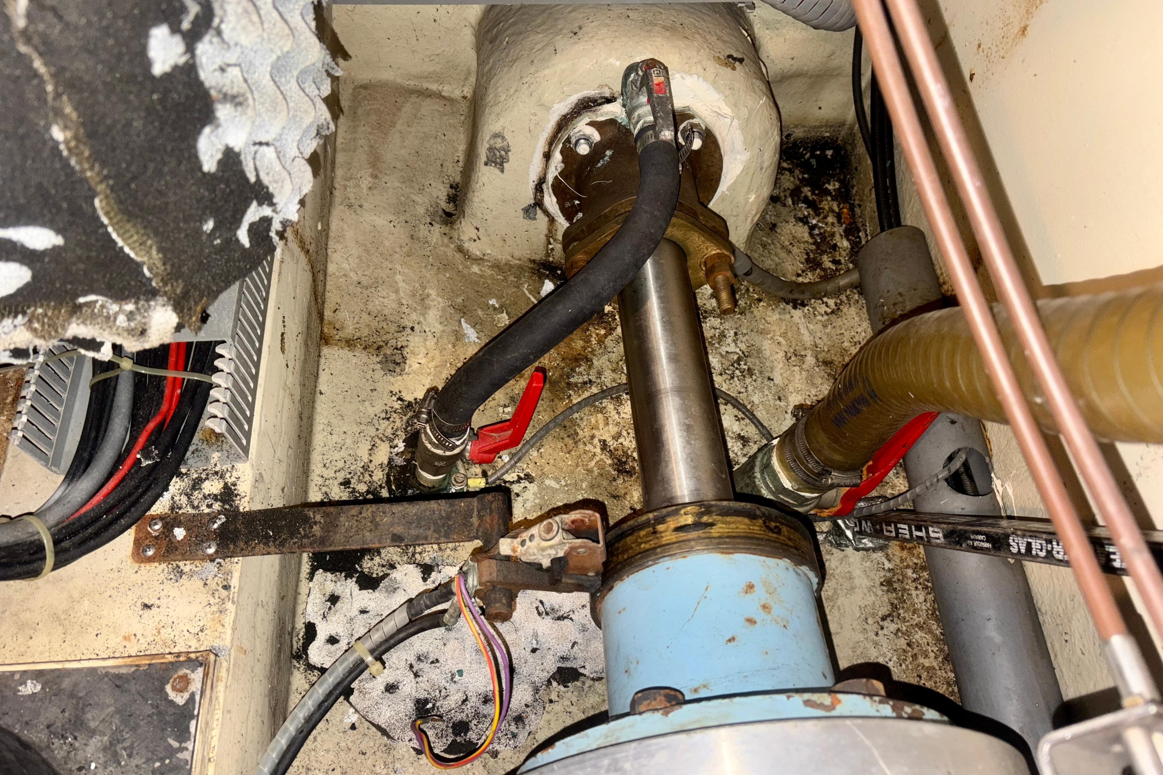 Engine room of 1990 Neptunus 145 AC yacht, showing mechanical components and hoses.
