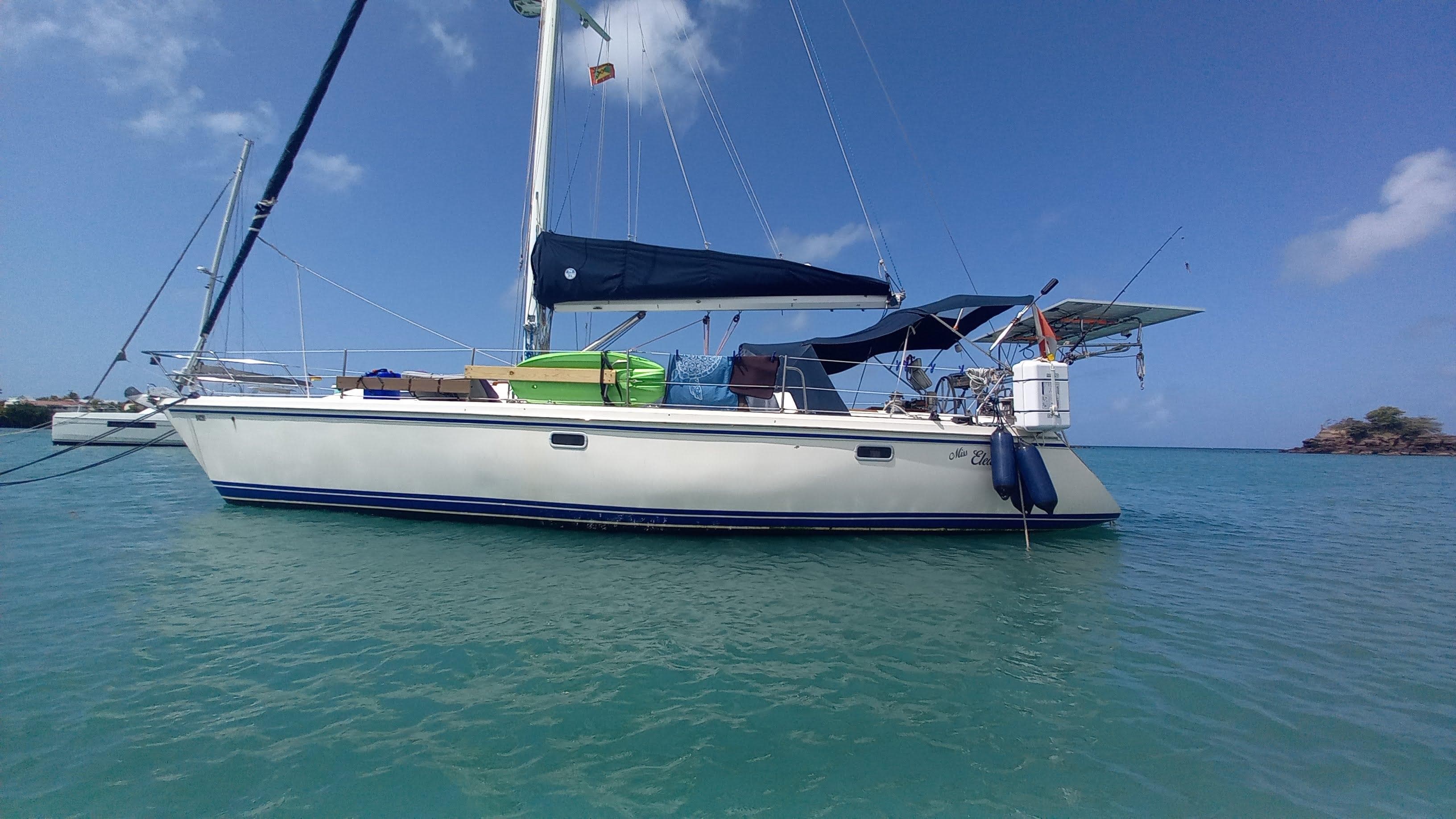 Catalina 42 sailboat from 1992 anchored in clear blue water under a sunny sky.