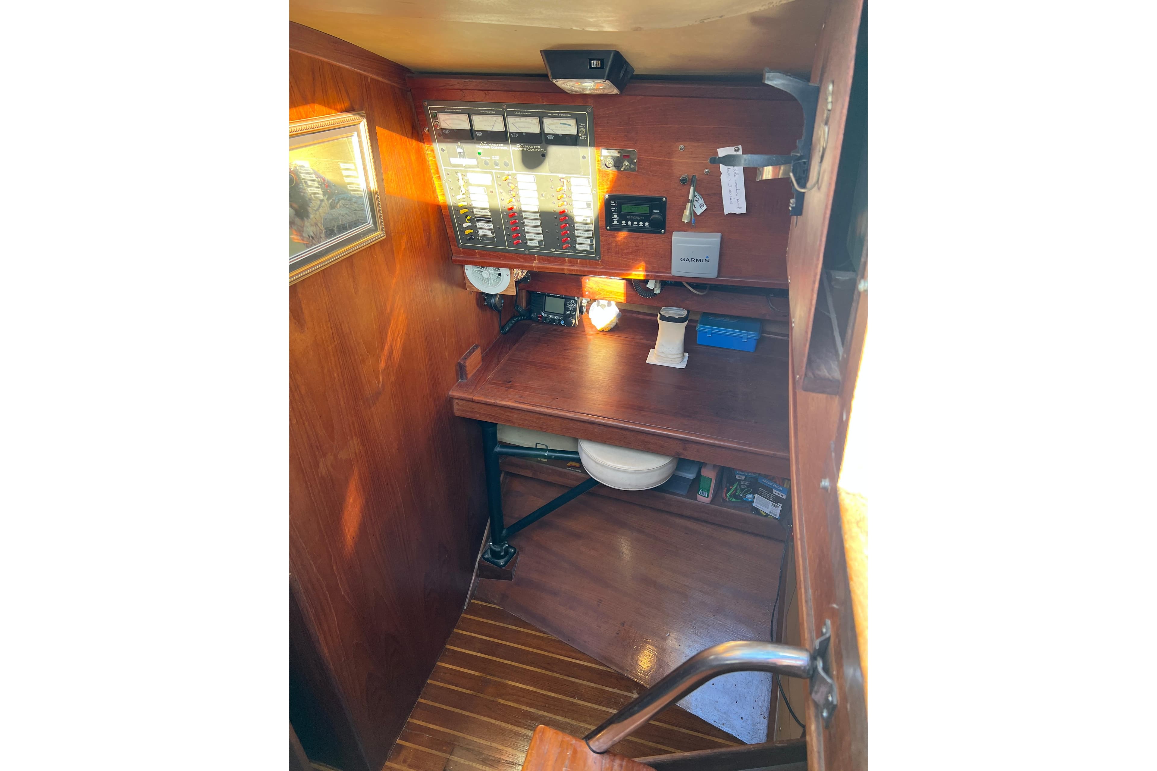 Navigation station inside a 1979 Pearson 424 sailboat, featuring wooden interior and control panels.
