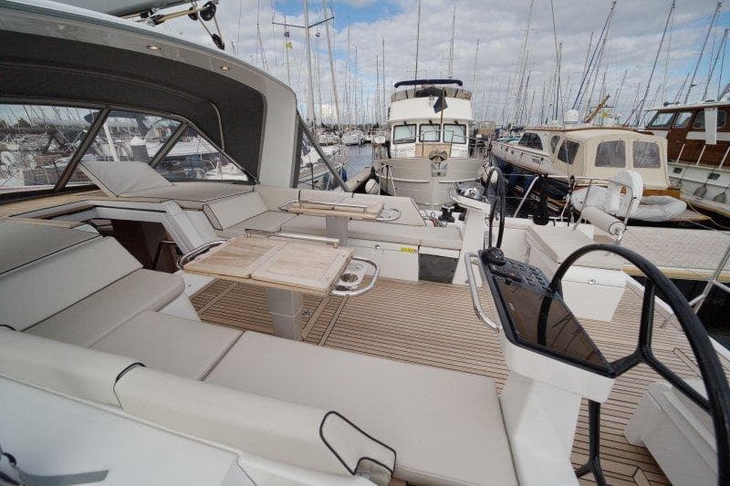 Luxurious 2022 Beneteau Oceanis Yacht 54 interior with elegant seating and steering wheel.