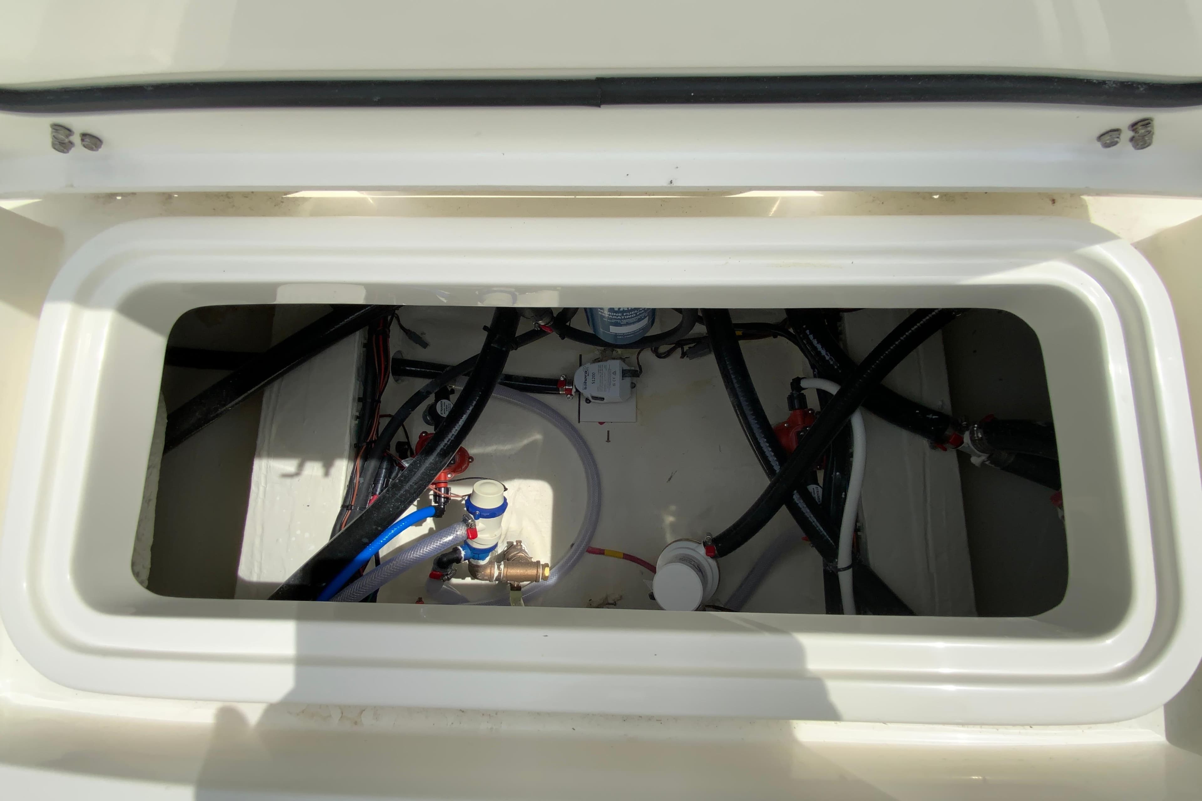 Open hatch of 2026 Pathfinder 2600 TRS boat showing internal wiring and plumbing.