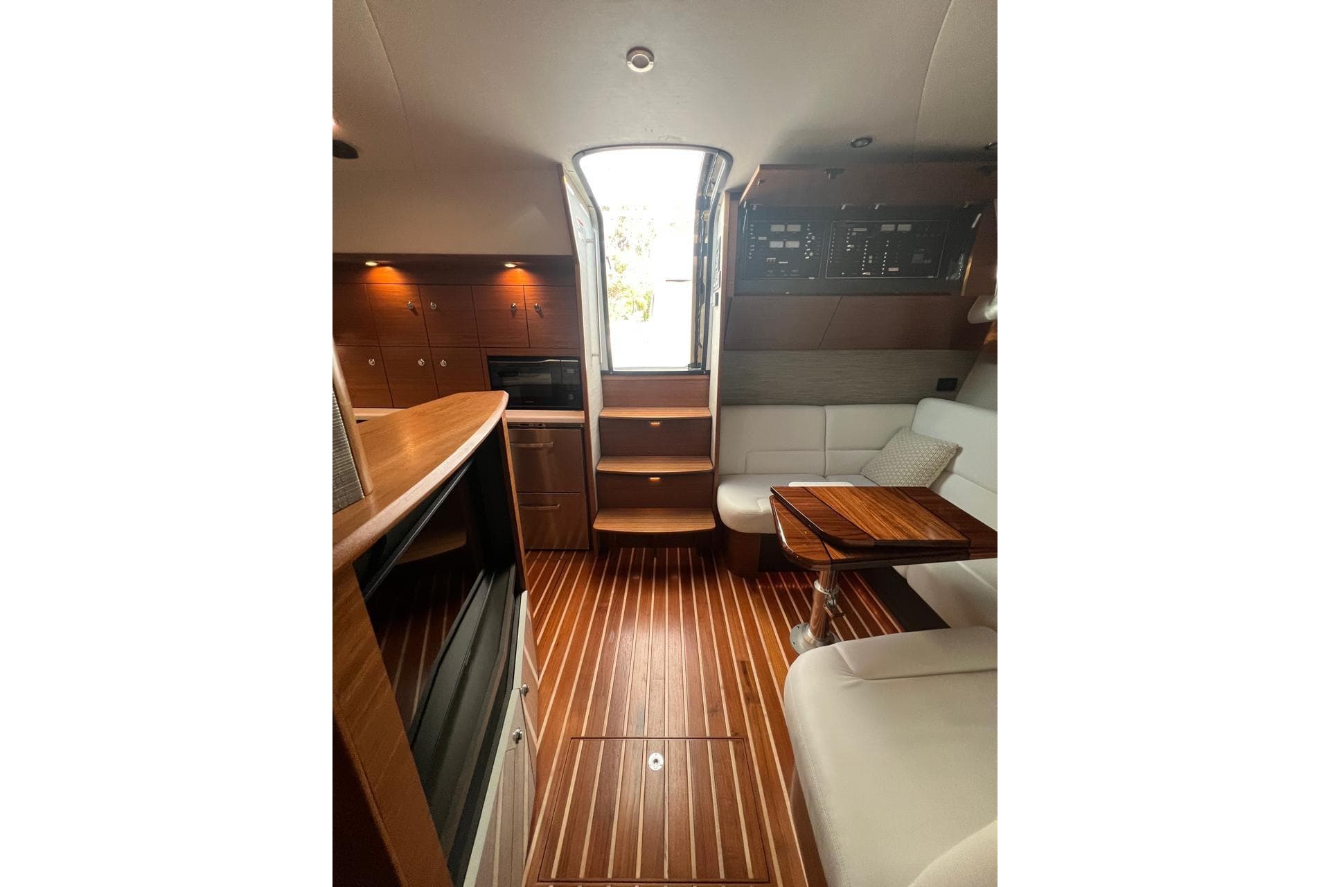 Interior of 2020 Tiara Yachts 43 Open with wood flooring and seating area.