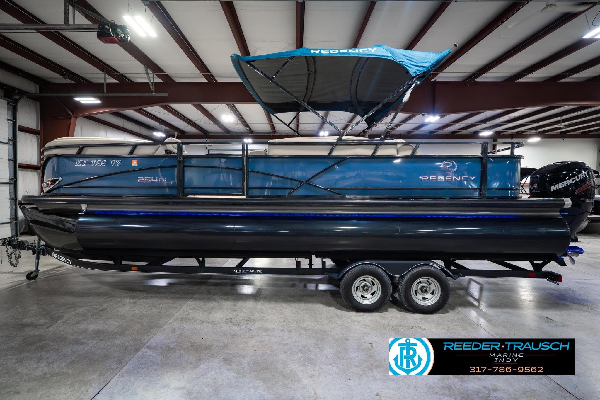 2018 Regency 254 DL3 pontoon boat with canopy in indoor showroom.