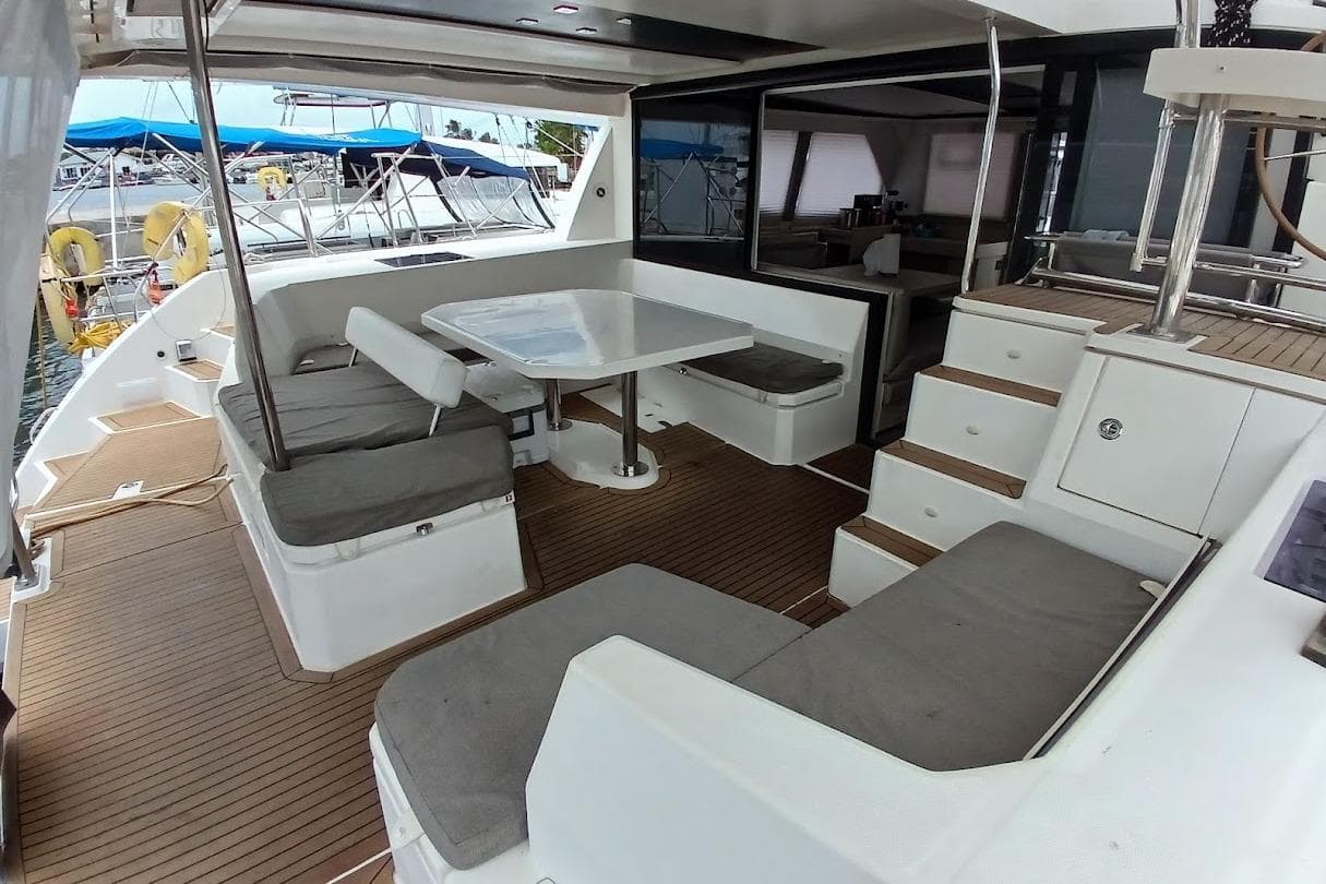 Spacious deck of 2019 Leopard 45 catamaran with seating and table.