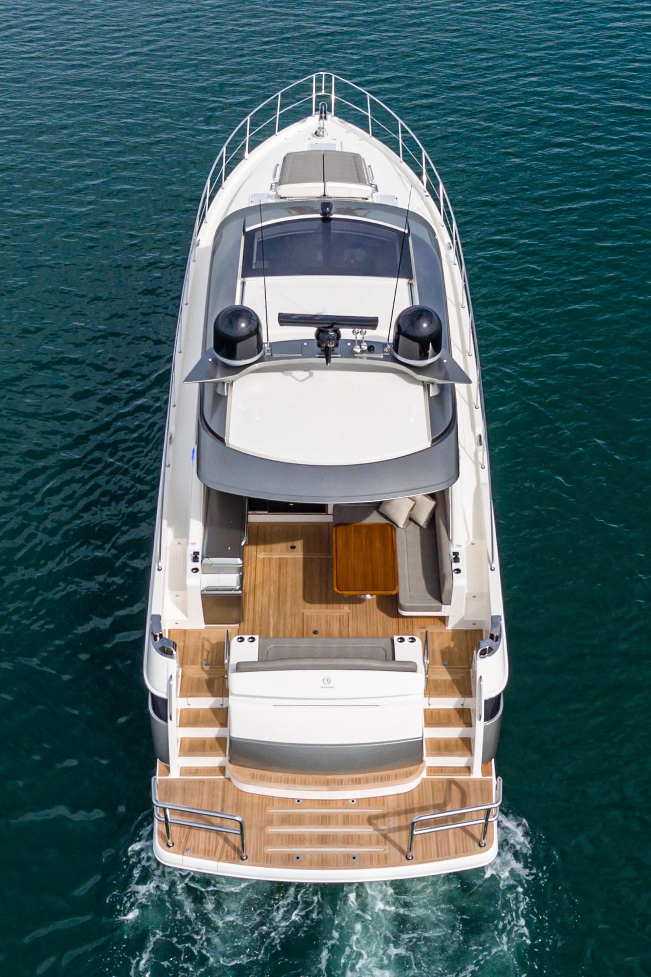 2020 Riviera 5400 Sport Yacht cruising on clear blue water, aerial view.