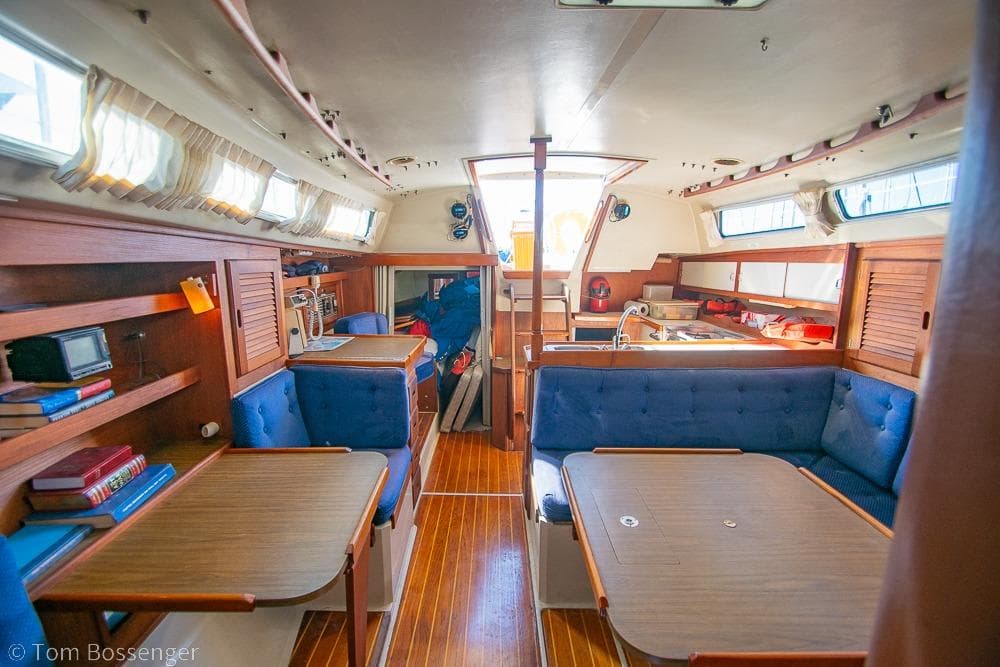 Interior of a 1987 Catalina 36 sailboat with wooden furnishings and blue seating.